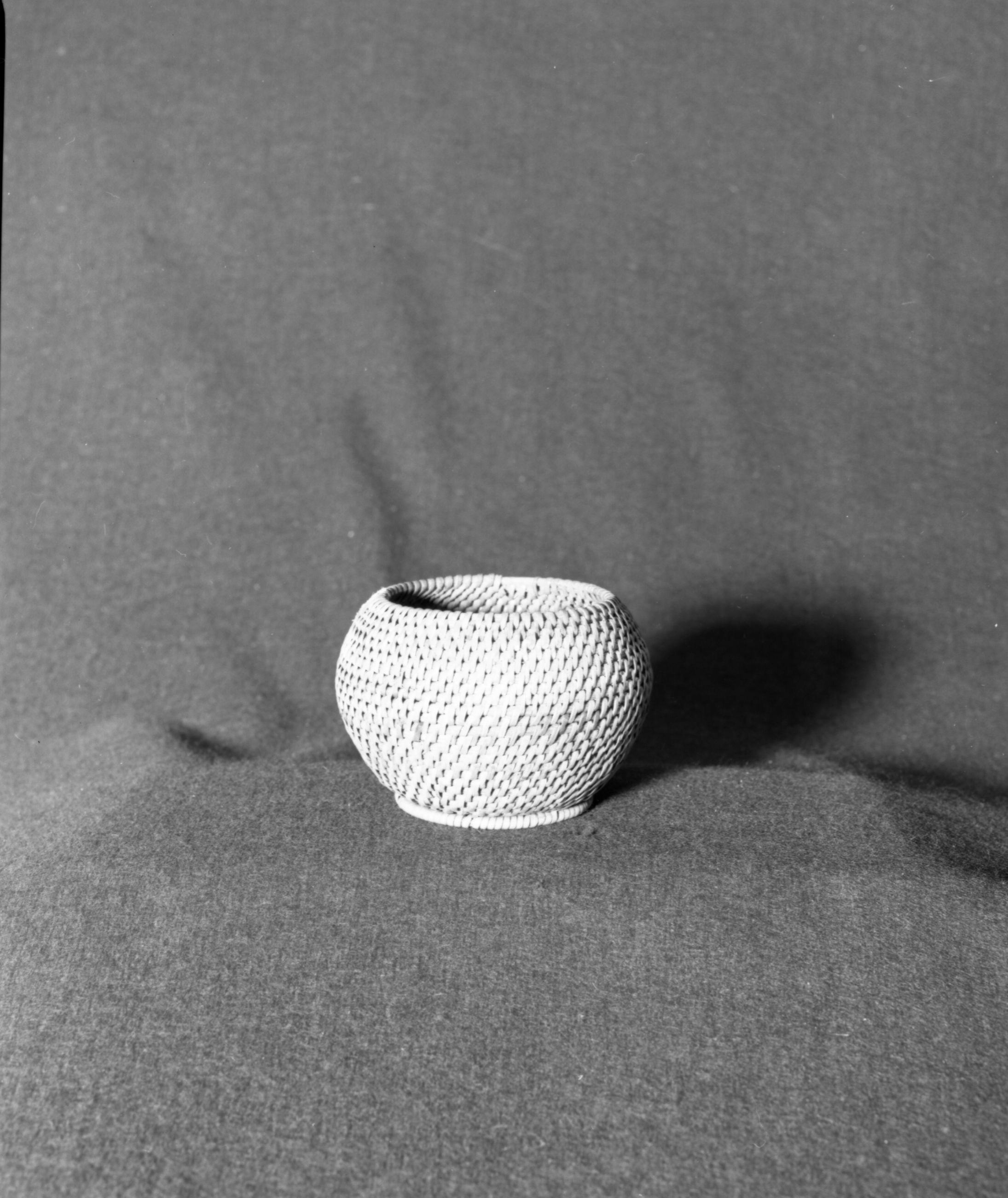 Marie Rozier Collection, Catalog No. 25. Object: Chinese basket. Dimensions: 3 1/2 x 4 1/2". Materials: Split rattan, reed. Technology: Single rod, interlocking stitch. Collection History: Type commonly exported from China in early 20th Century. Gift of G. DuGay. Photographed by Michael Dixon in December 1982. Catalogued by Craig Bates and Barbara Beroza. Yosemite Collections, National Park Service.