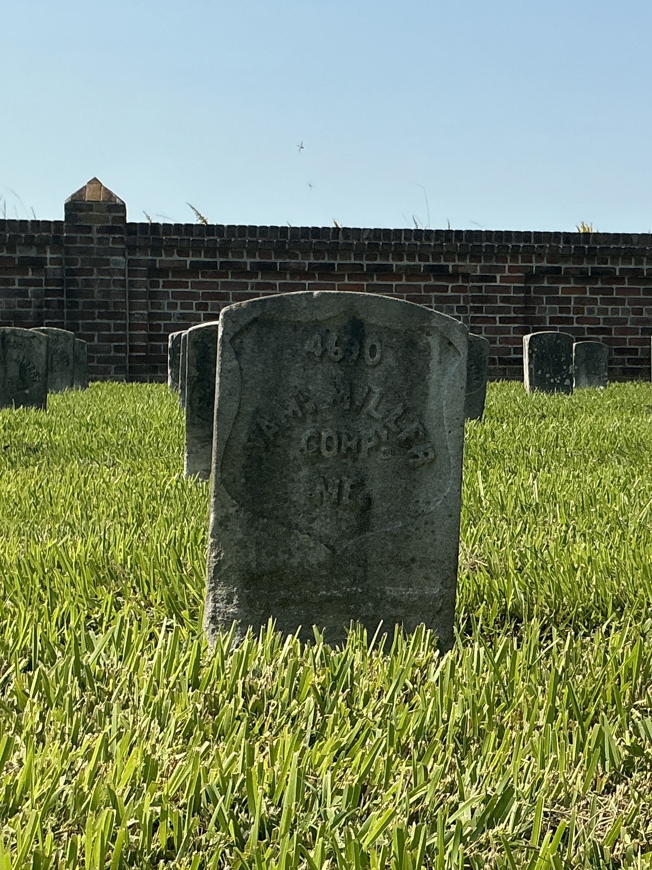 Front of historic upright marble headstone with recessed shield face.