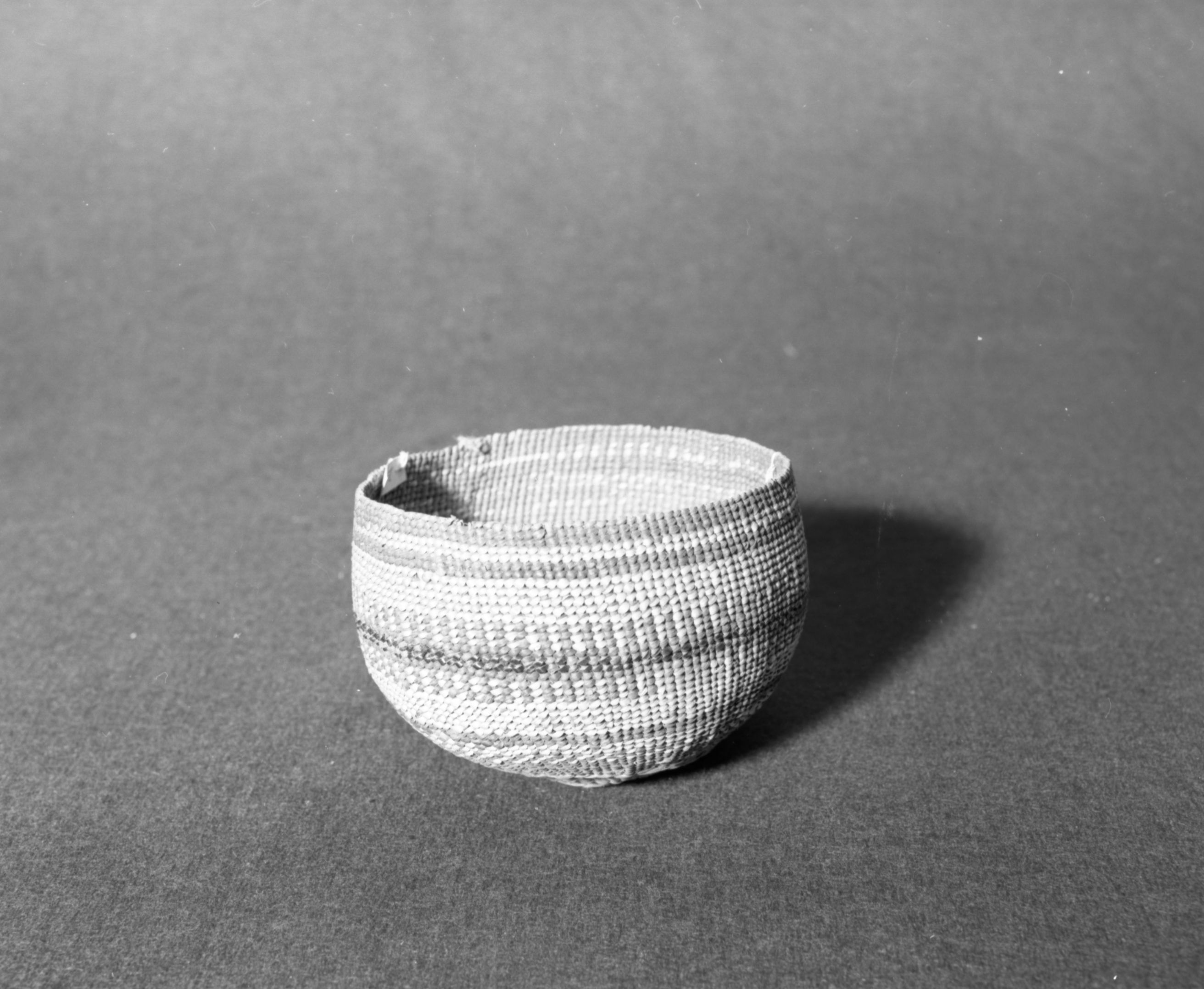 Marie Rozier Collection, Catalog No. 134. Object: Northwestern California basket. Dimensions: 6 x 4". Materials: Conifer root; beargrass; maidenhair fern stem; alder-bark-dyed woodwardia fern stem. Technology: Up to right slant of turns; three-strand twined start. Collection History: Gift of Ora Doyle. appears to be mate to 133. Photographed by Michael Dixon in December 1982. Catalogued by Craig Bates and Barbara Beroza. Yosemite Collections, National Park Service.