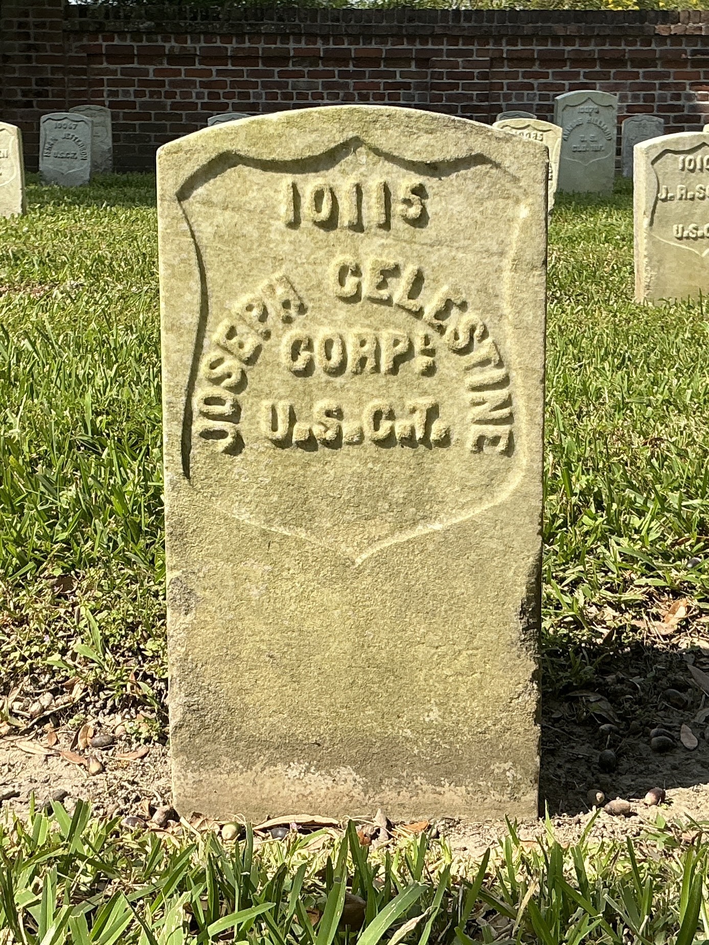 Front of historic upright marble headstone with recessed shield face.