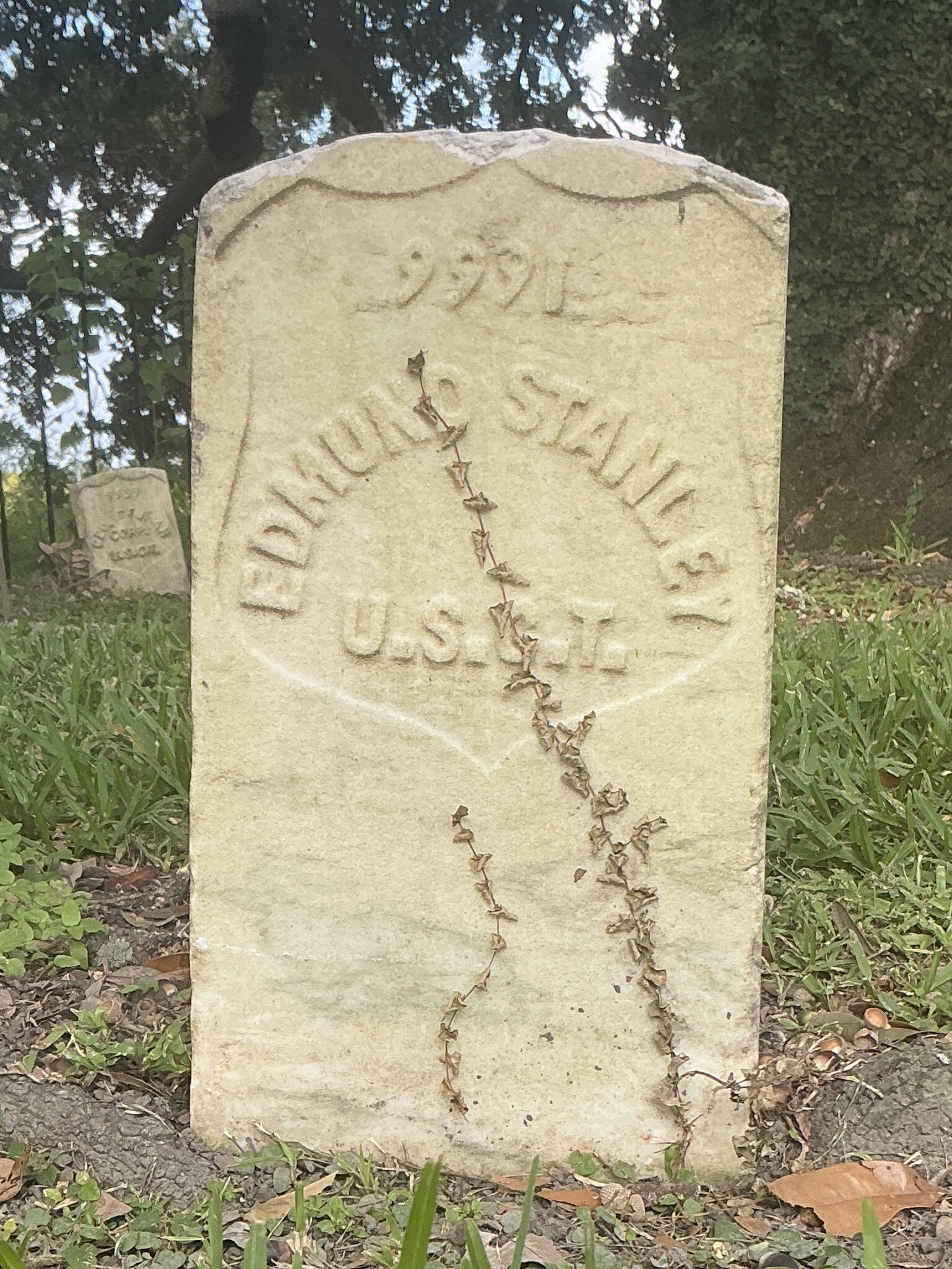 Front of historic upright marble headstone with recessed shield face.