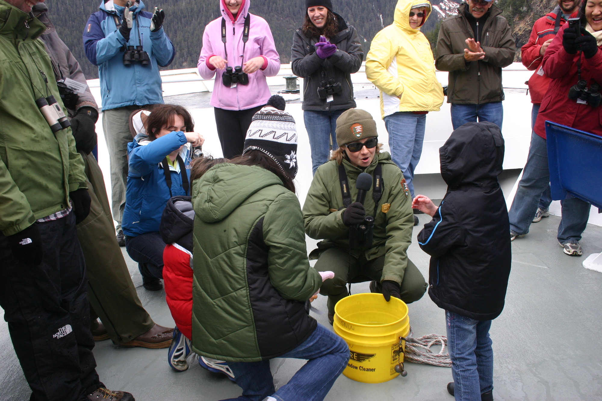 Interpretive Ranger Jen Linkhart works with Junior Rangers on the blubber mitt activity aboard the M/V Star of the Northwest