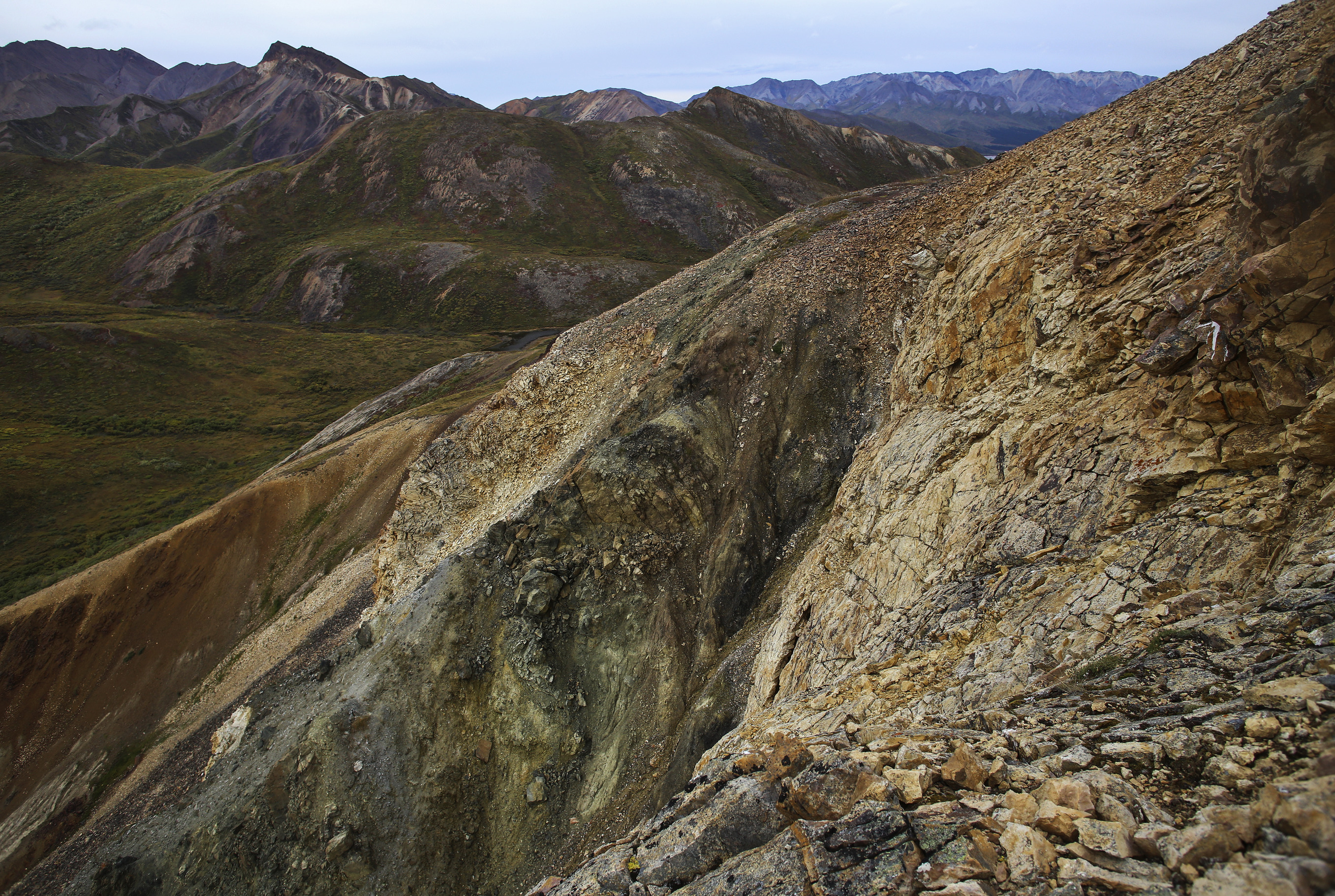 a steep drop off a mountainside over a valley