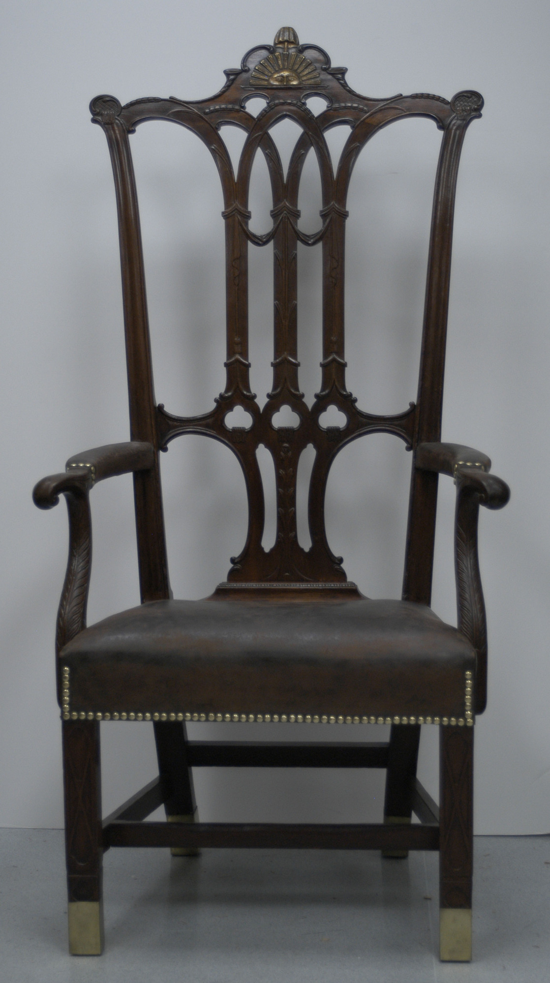 Large mahogany armchair with leather upholstered seat, pierced decorative back splat and carved sun in top crest rail.