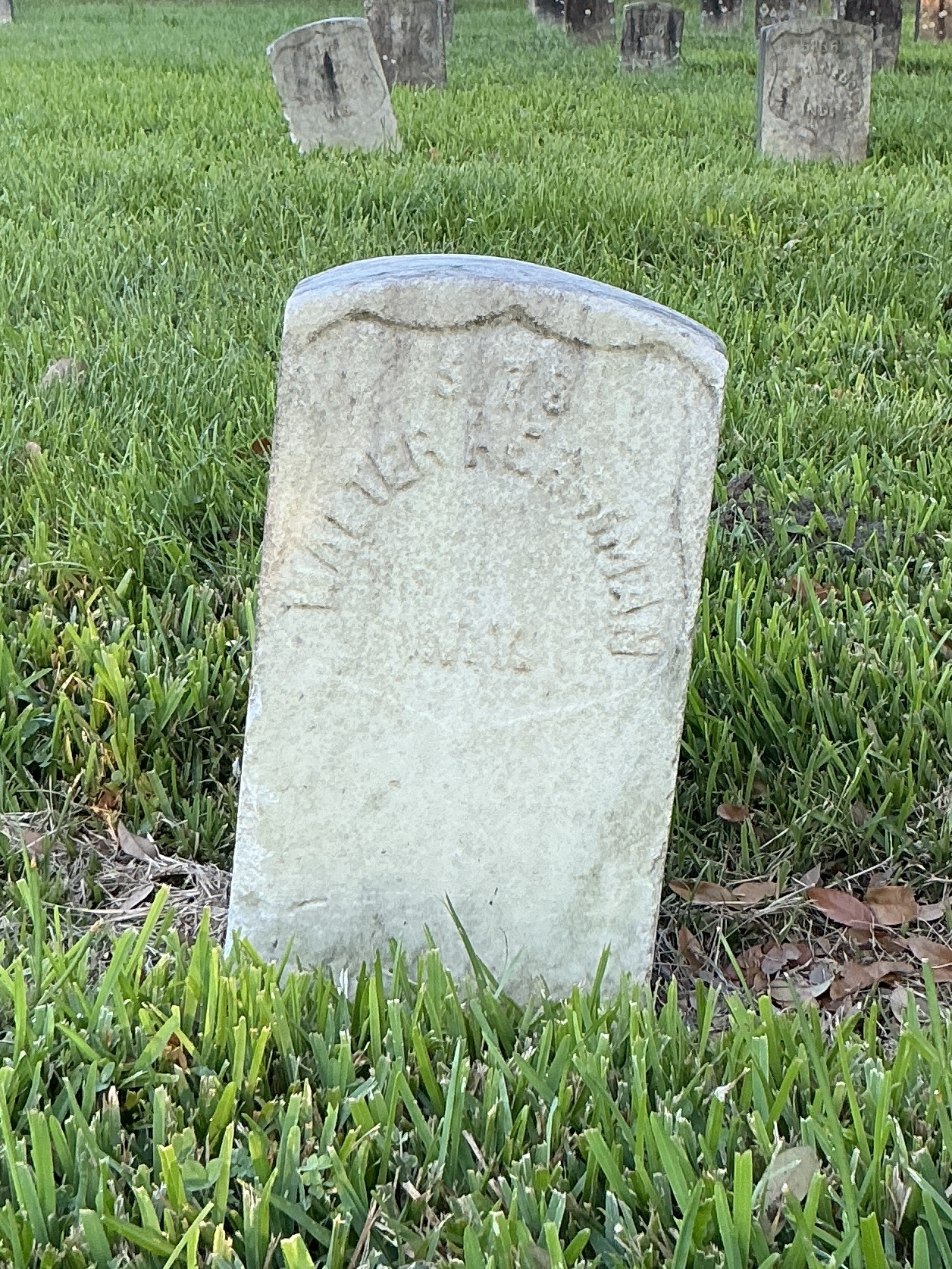 Front of historic upright marble headstone with recessed shield face.