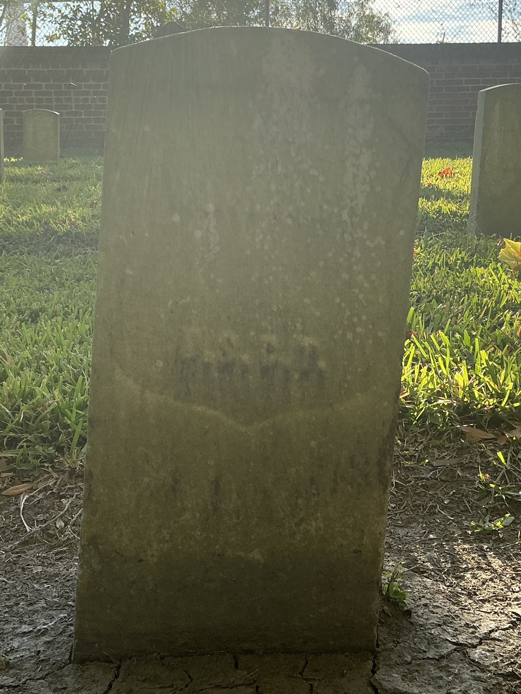 Front of historic upright marble headstone with recessed shield face.