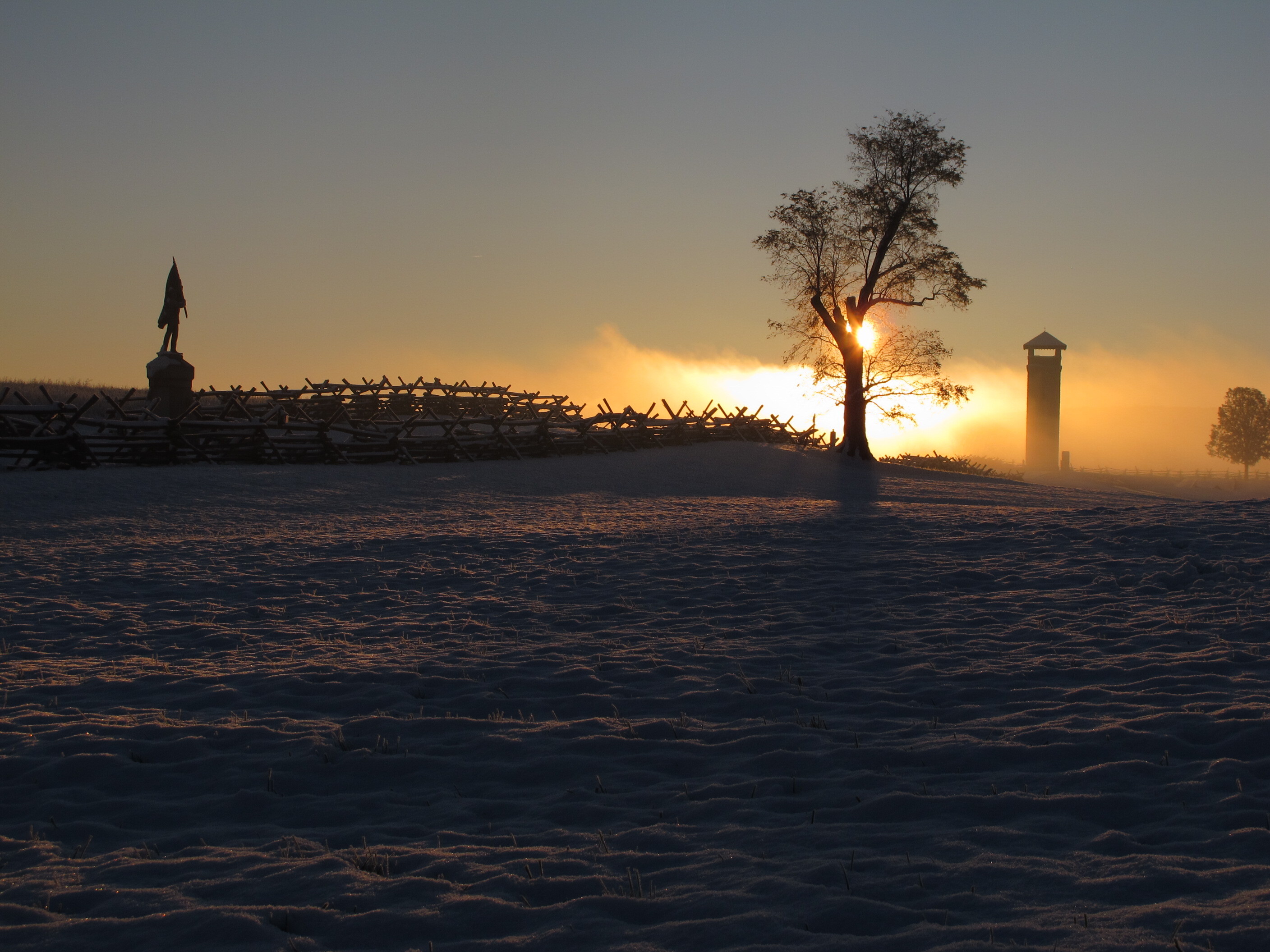 dramatic sunrise monument tree fence and tower visible