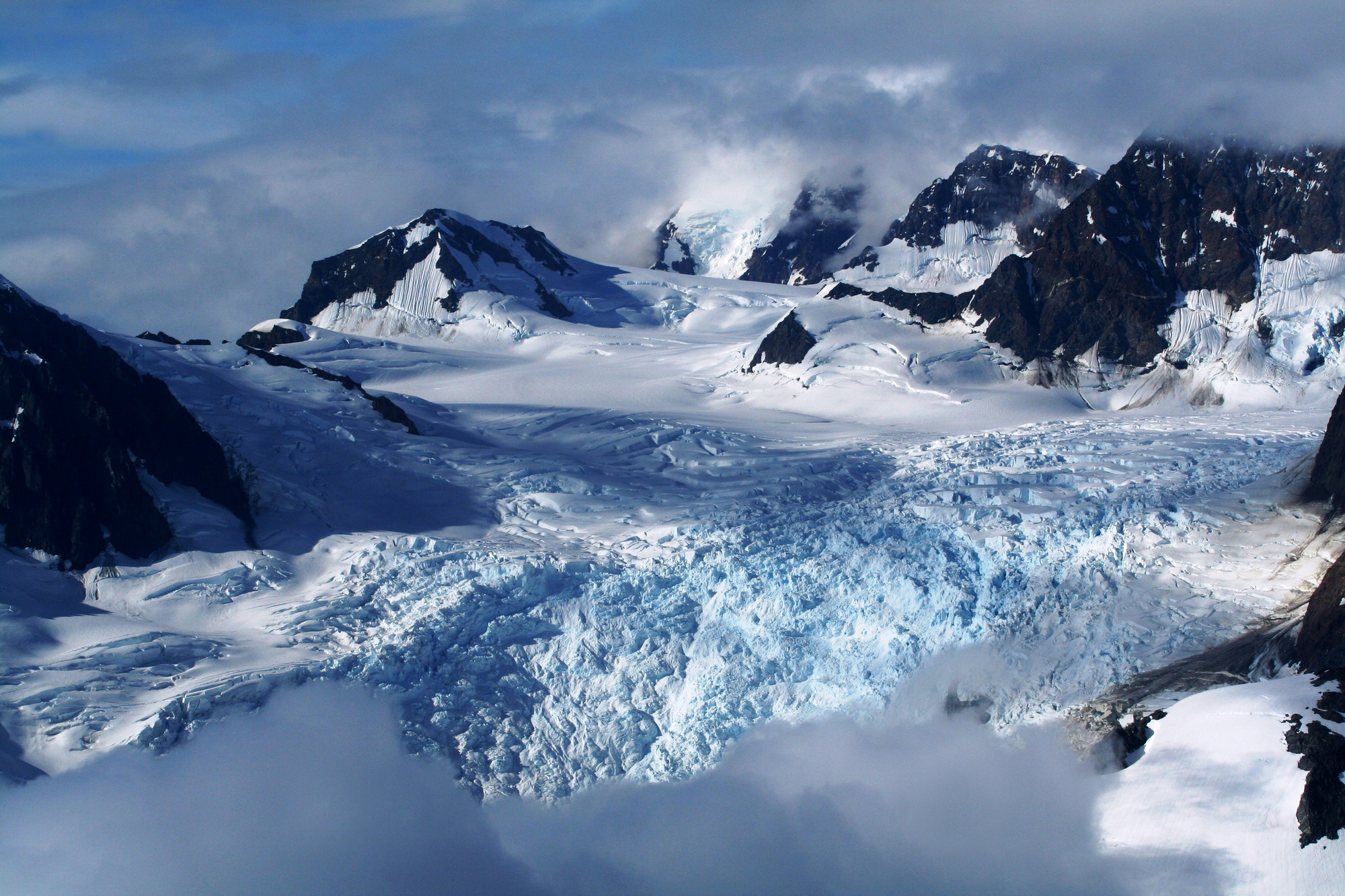 Glacier is covered in patches by fog and clouds