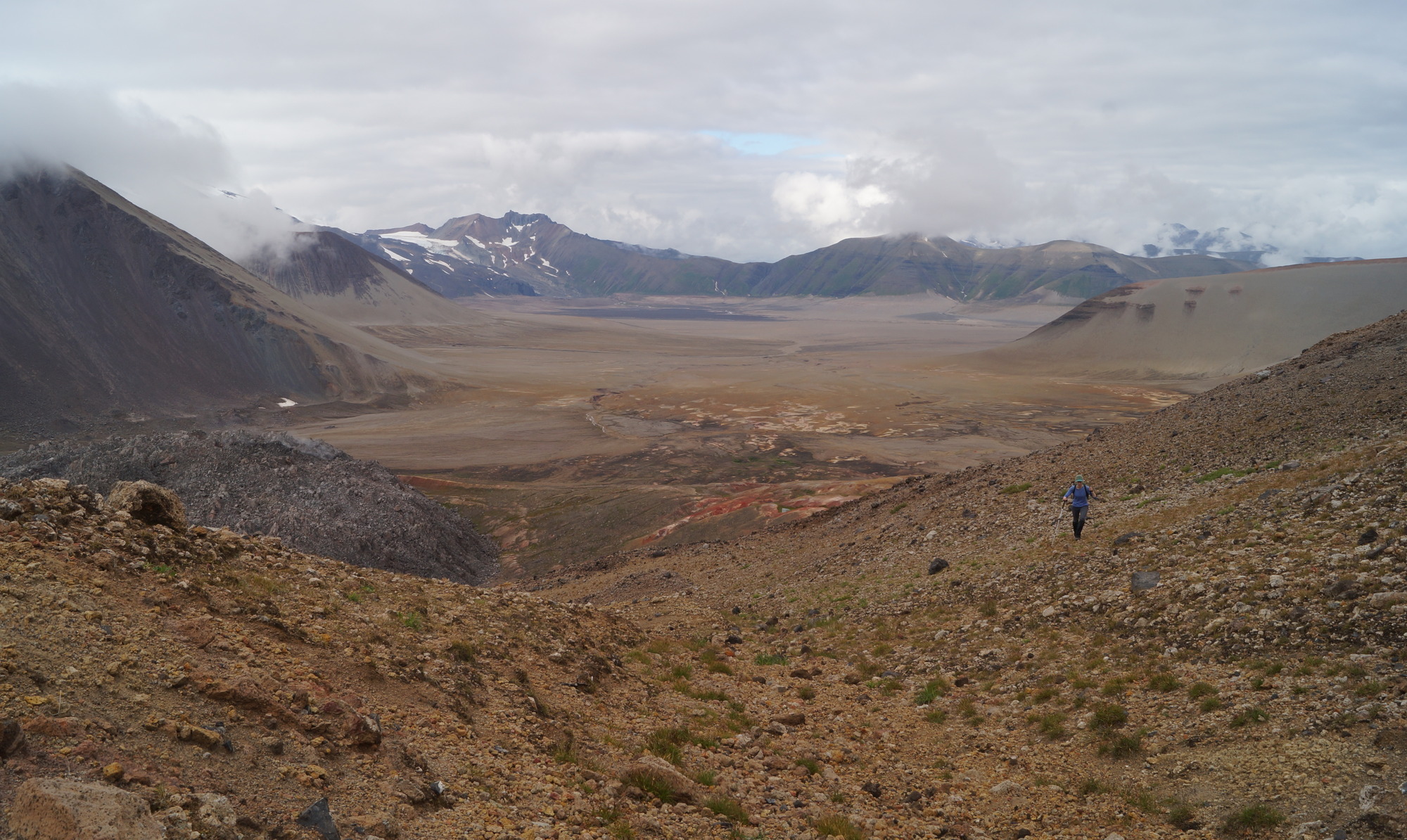The upper Valley of Ten-thousand Smokes, with cinder cone Novarupta in the left-center view. Hiker for scale. Katmai National Park, AK.