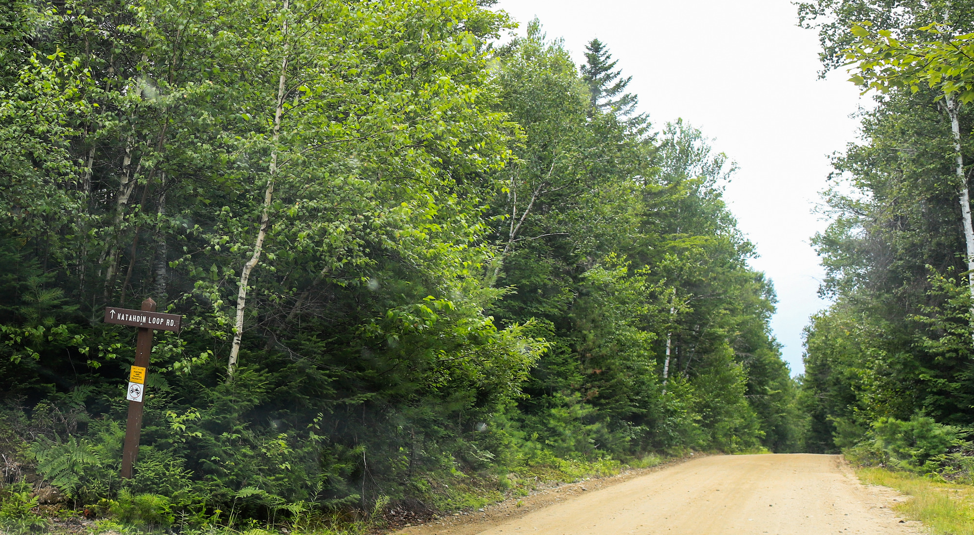 A sign on the side of the road indicating "Katahdin Loop Rd" is ahead