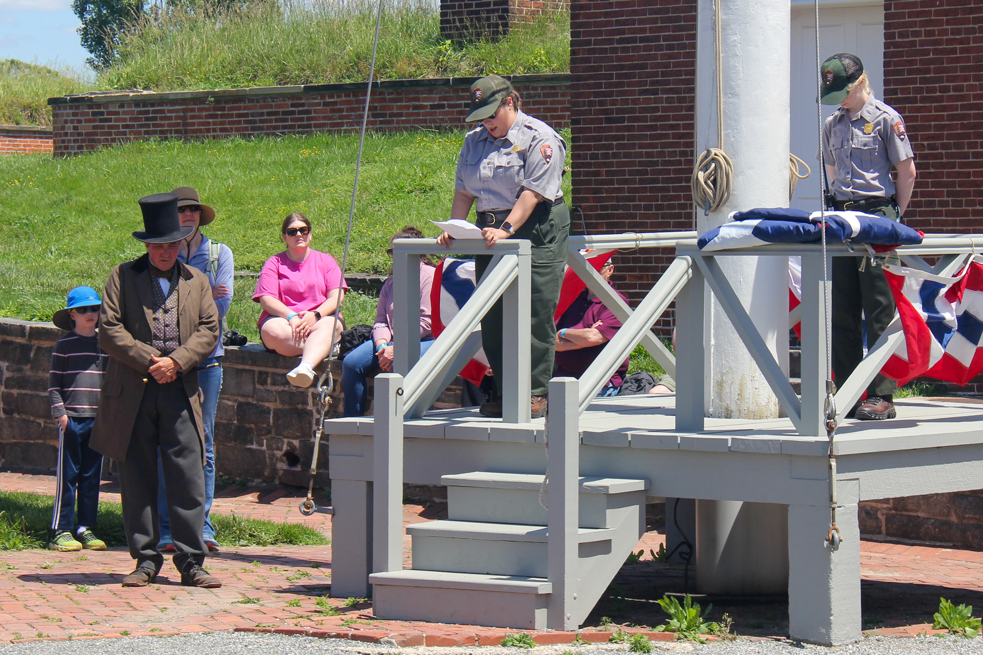 NPS Ranger reading to crowd from the flag pole platform.