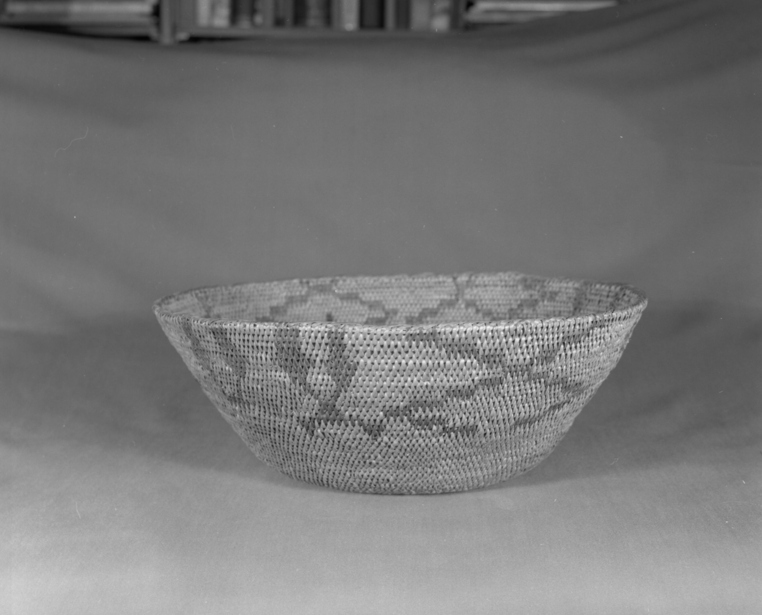 Private Collection. Object: Miwok basket. Dimensions: 13 x 4 1/2". Materials: Redbud and bull pine. Technology: Singe rod, fag ends trimmed on work face, moving ends trimmed on interior. Leftward coil direction. Rim overstitched three times. Start not overstitched. Collection History: Made by Matilda, a Sonora Miwok, c. 1920. Photographed by Michael Dixon. Catalogued by Craig Bates and Barbara Beroza. Yosemite Collections, National Park Service.