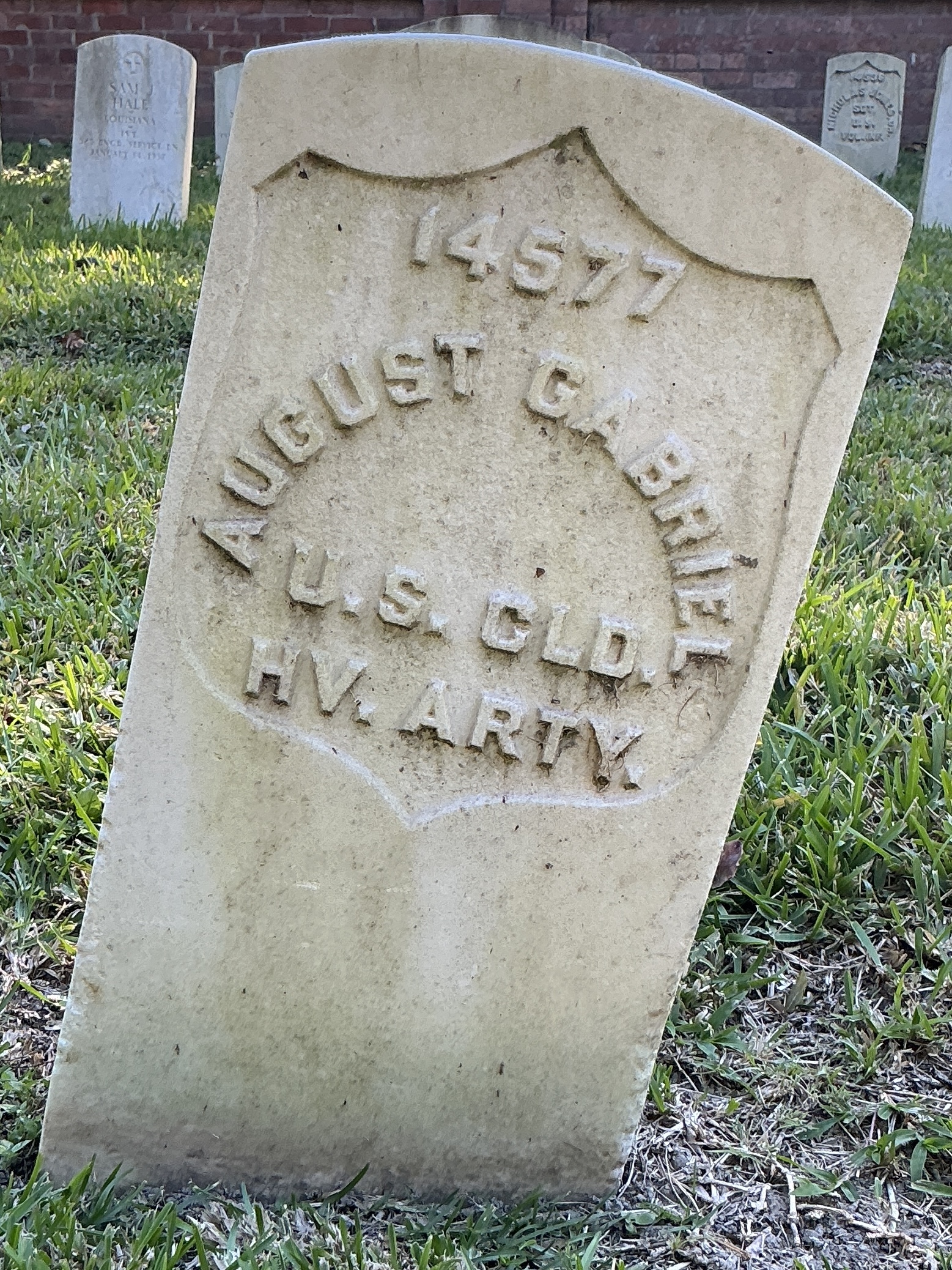 Front of historic upright marble headstone with recessed shield face.