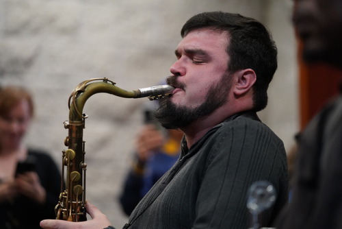  An emotional saxophonist performing on stage, passionately playing a golden saxophone.