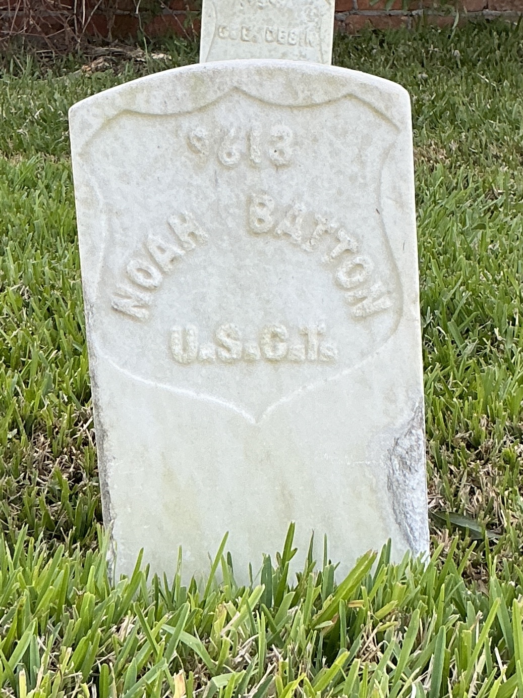 Front of historic upright marble headstone with recessed shield face.