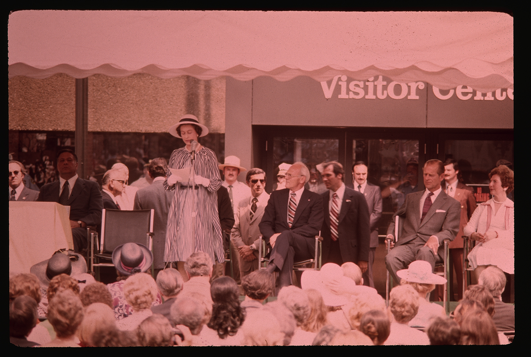 Queen's visit. (Old) Visitor Center (101 South 3rd Street). Exterior. Looking northeast at 3rd Street entrance. Queen Elizabeth II standing and speaking.