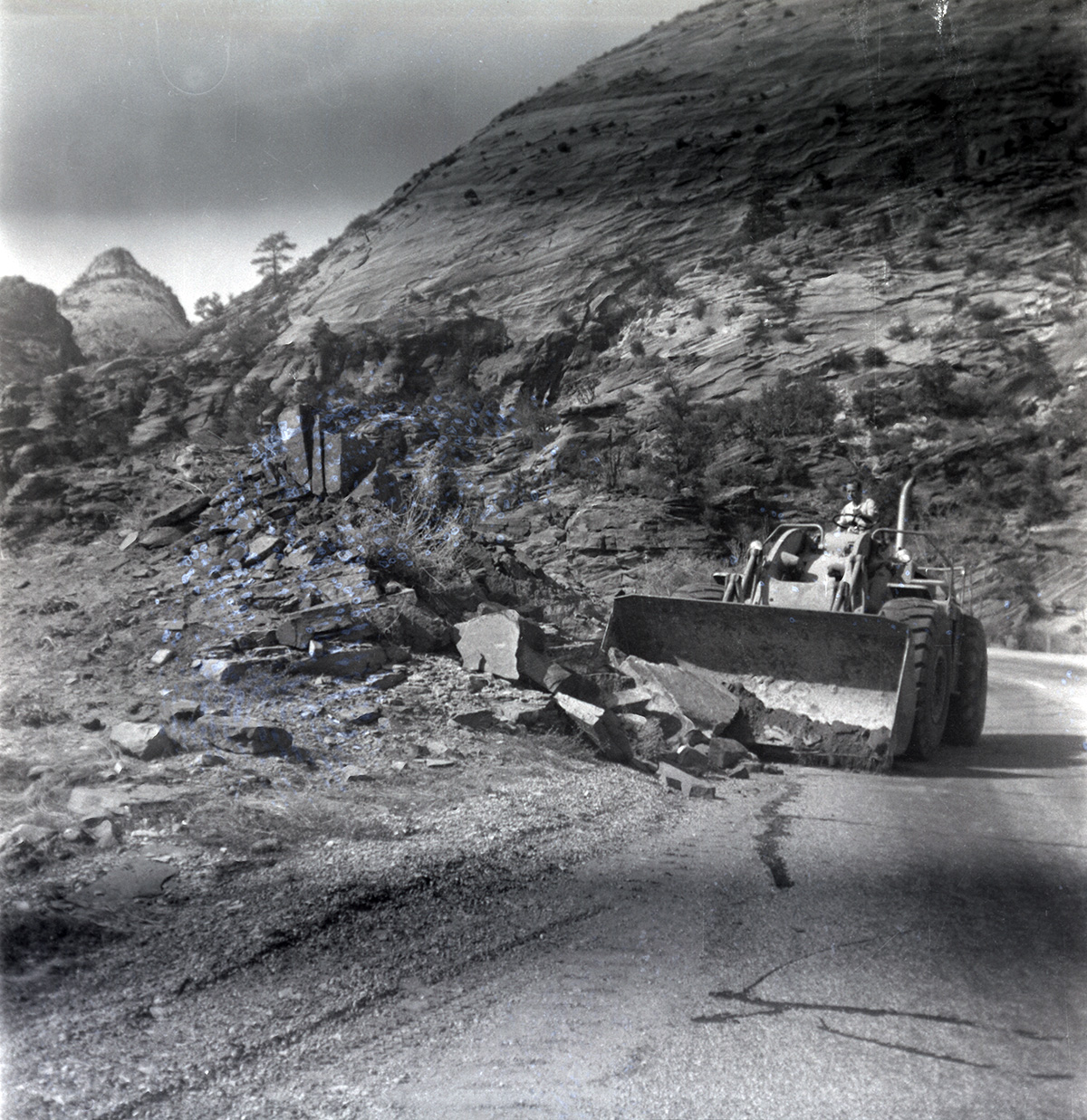 Construction vehicle clearing rocks during east side road repair and turn out construction.