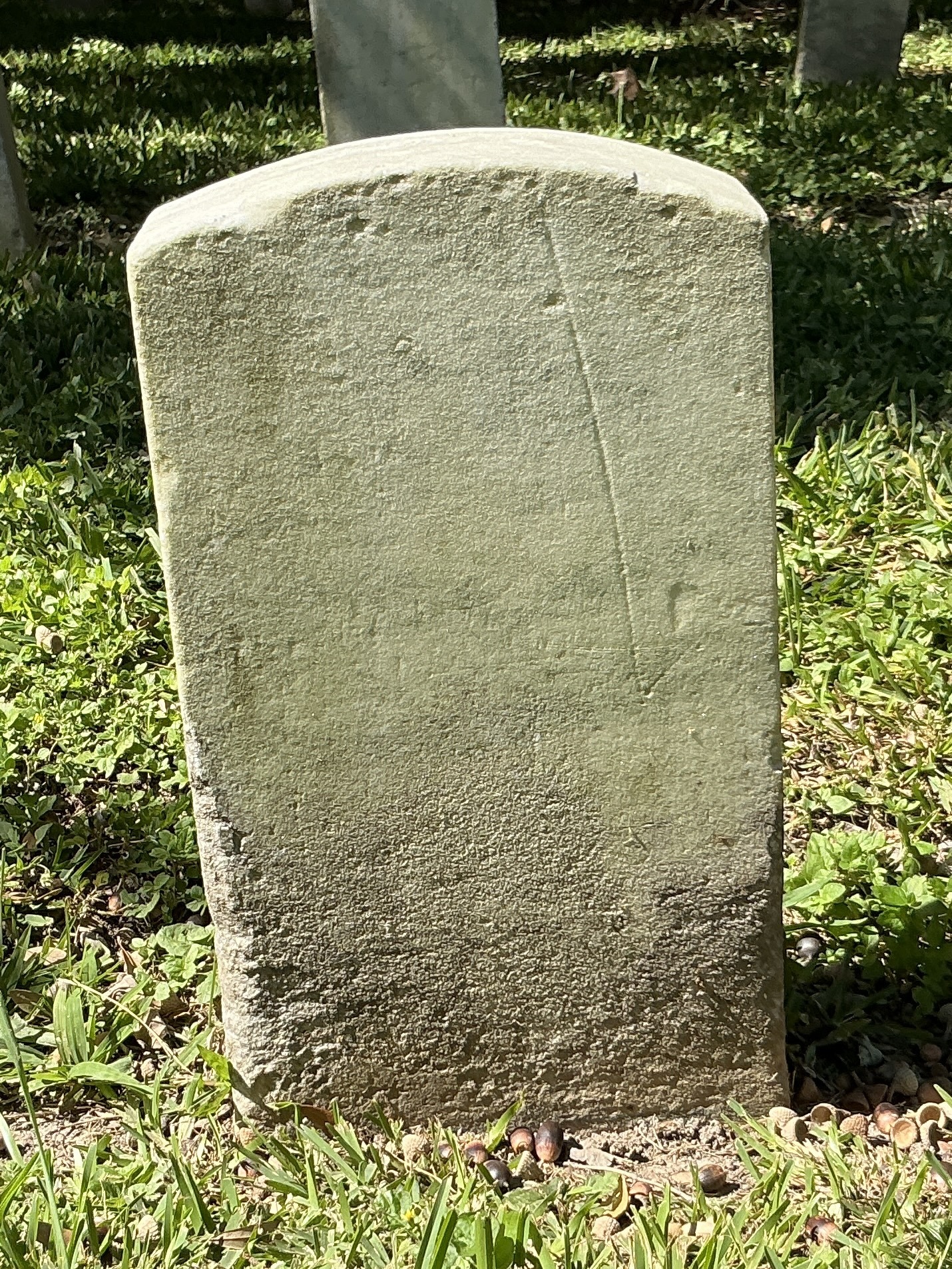 Back of historic upright marble headstone with recessed shield with recessed lettering face.