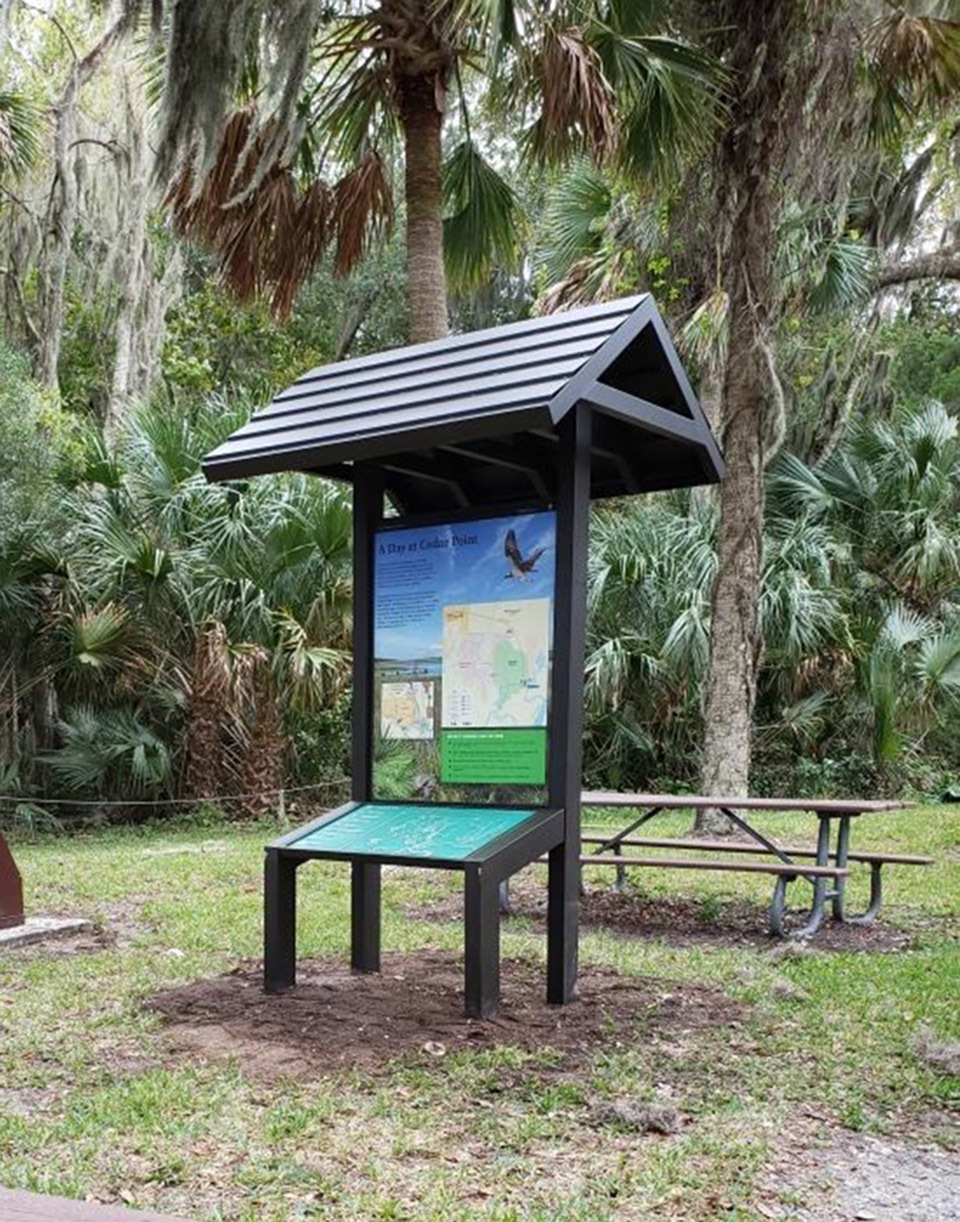 a small roof over a panel with a map and a tactile map below