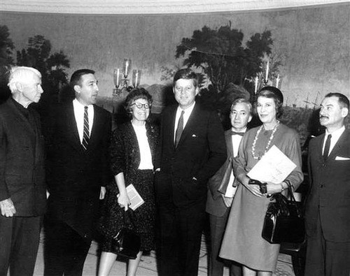 Group of seven adults, five men and 2 women, formally dressed and standing next to each other