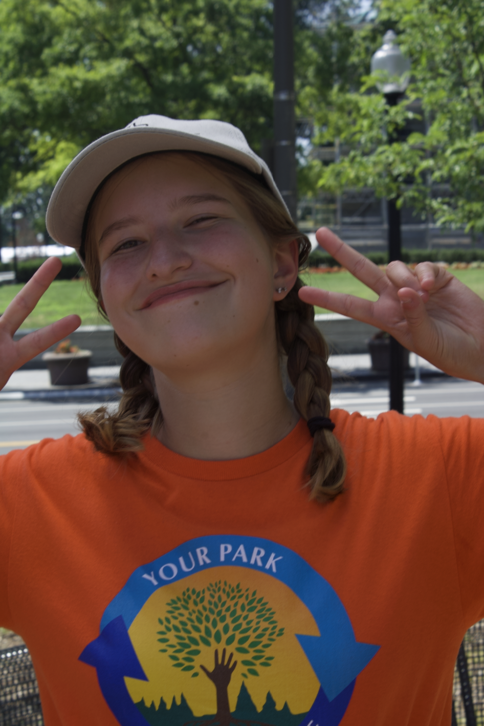 President's Park student volunteer, Elizabeth Smith smiling holding two peace signs.