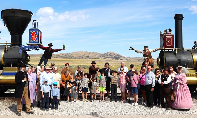 Visitors and Staff gather around the front of two historic locomotives