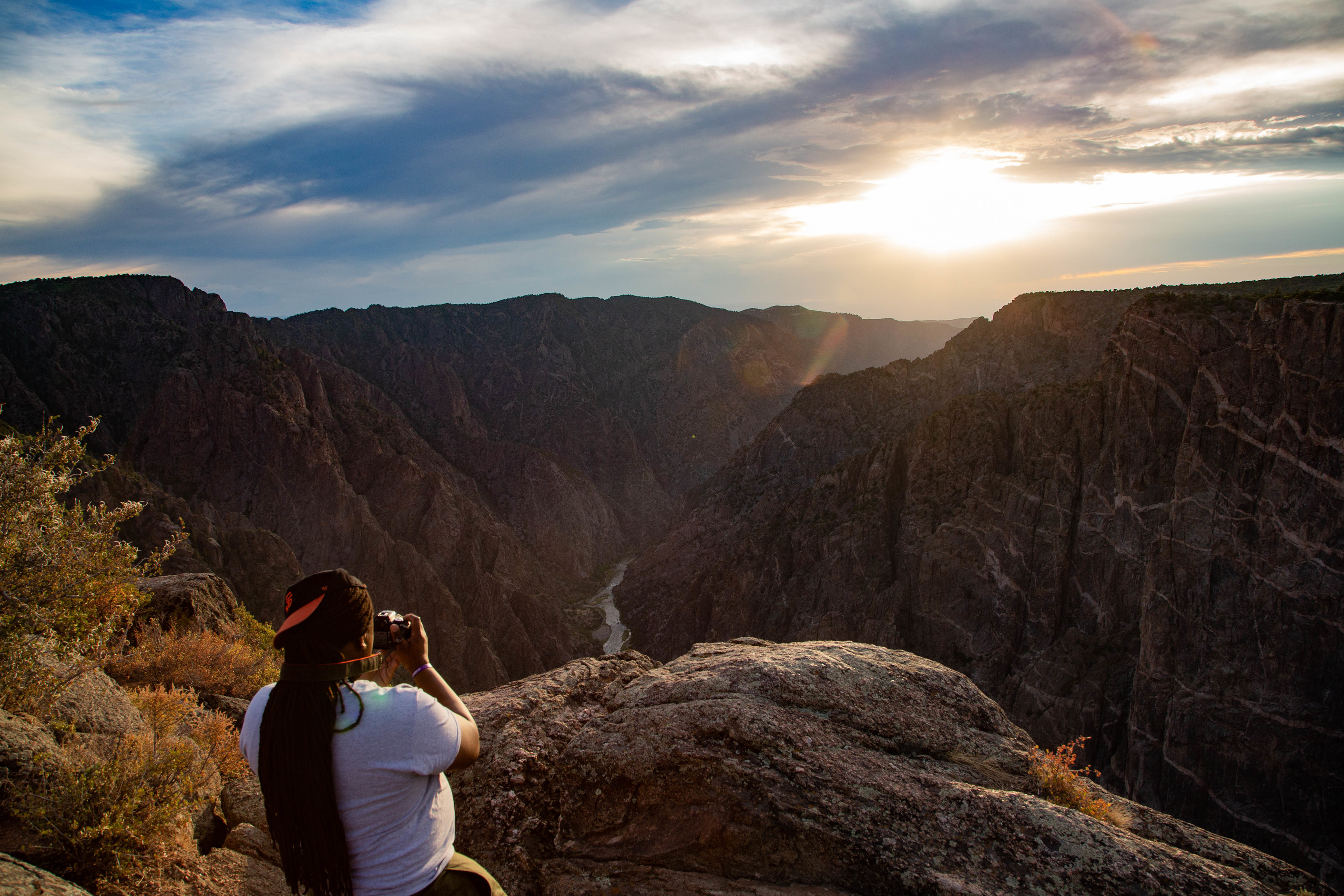 Photographer taking a picture of a river and canyon