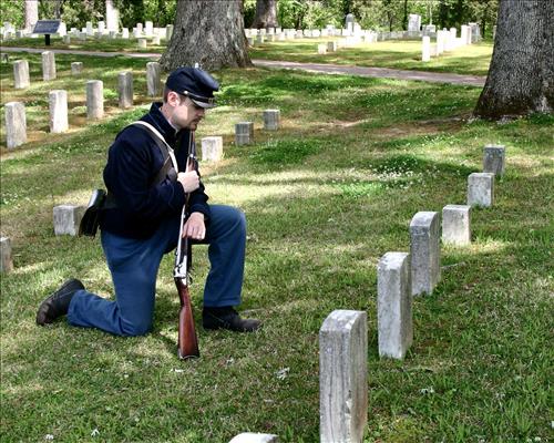 Park ranger in Civil War Union soldier costume poses in Shiloh National Cemetery