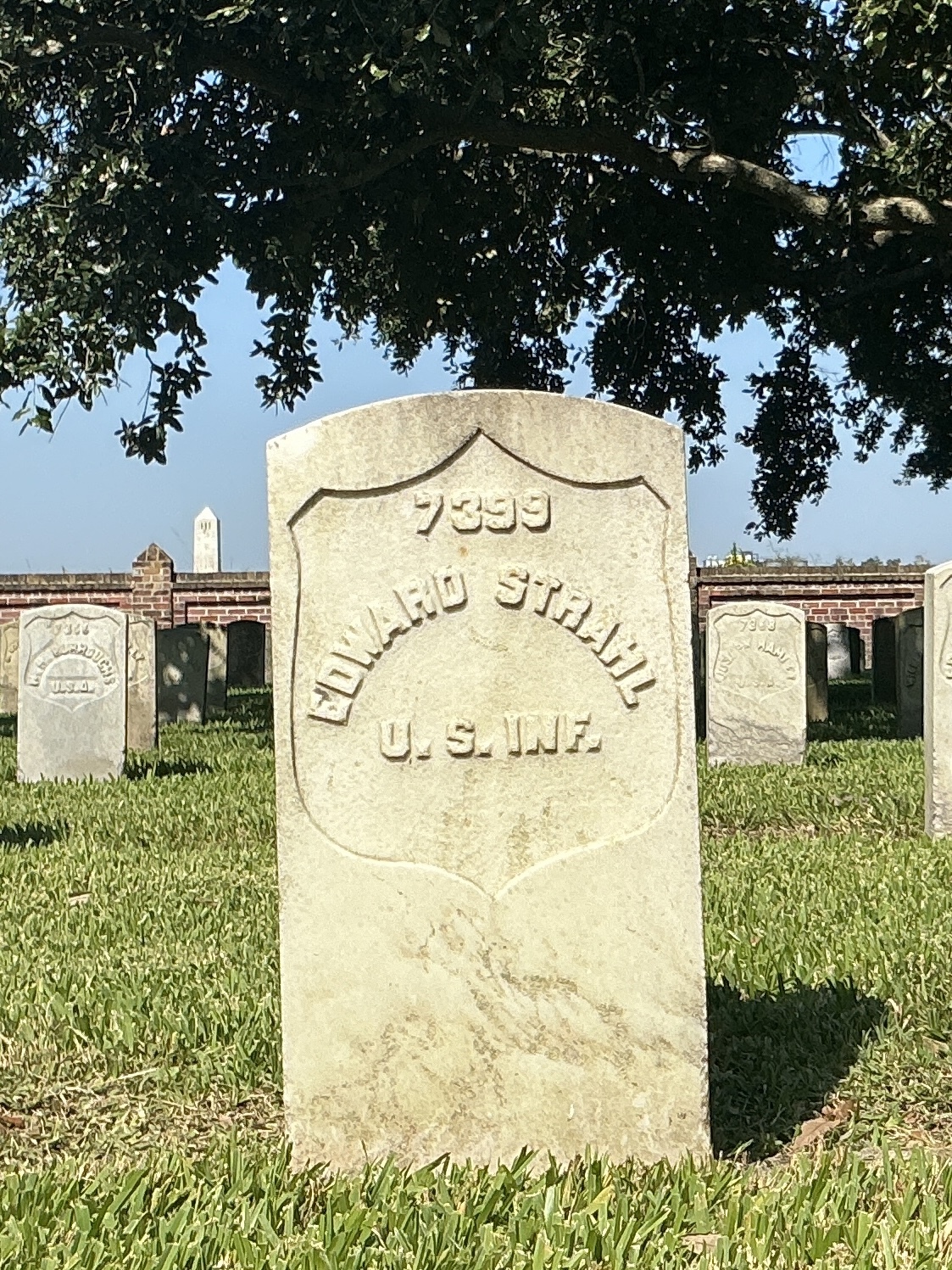 Front of historic upright marble headstone with recessed shield face.