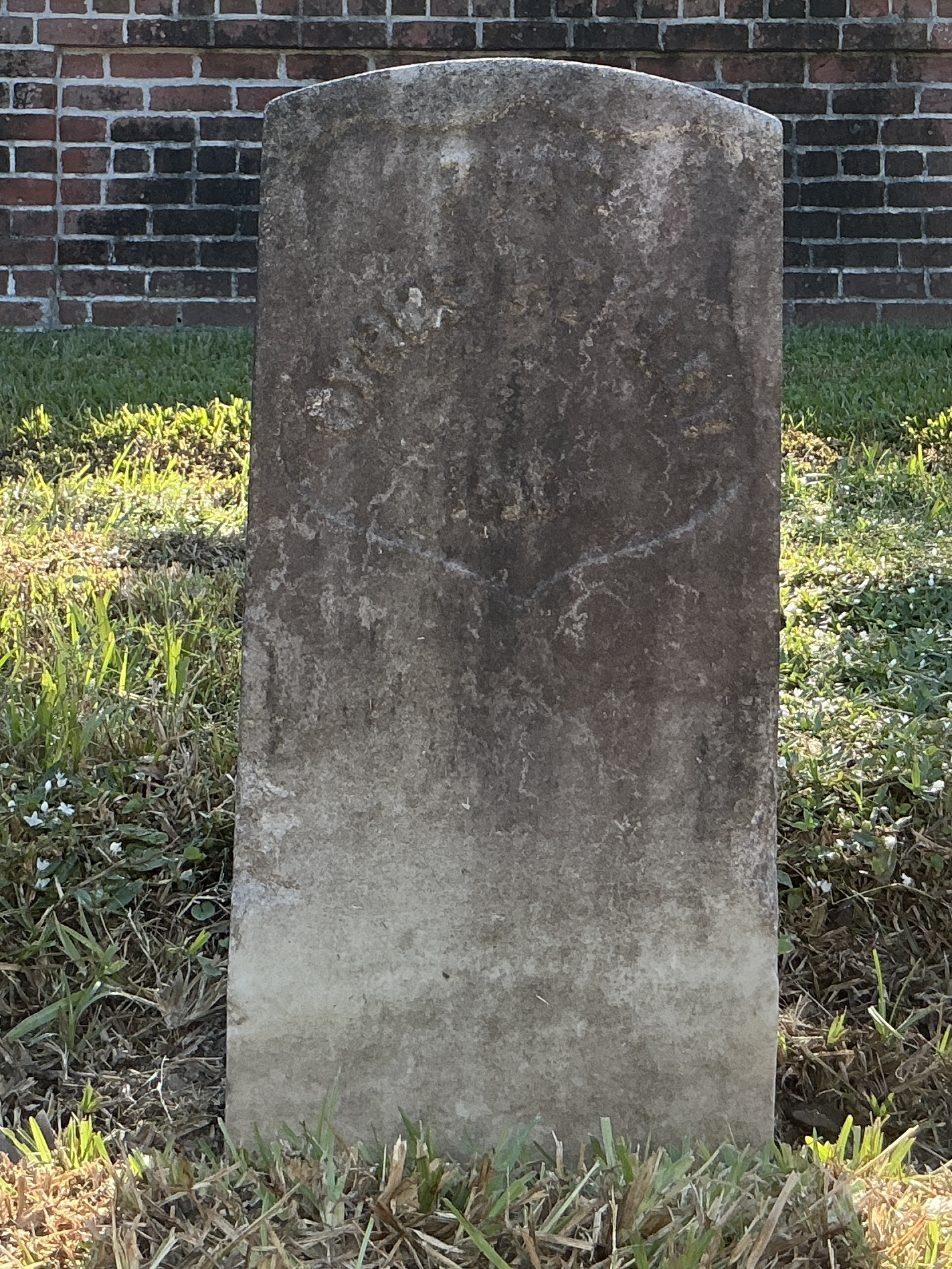 Front of historic upright marble headstone with recessed shield face.