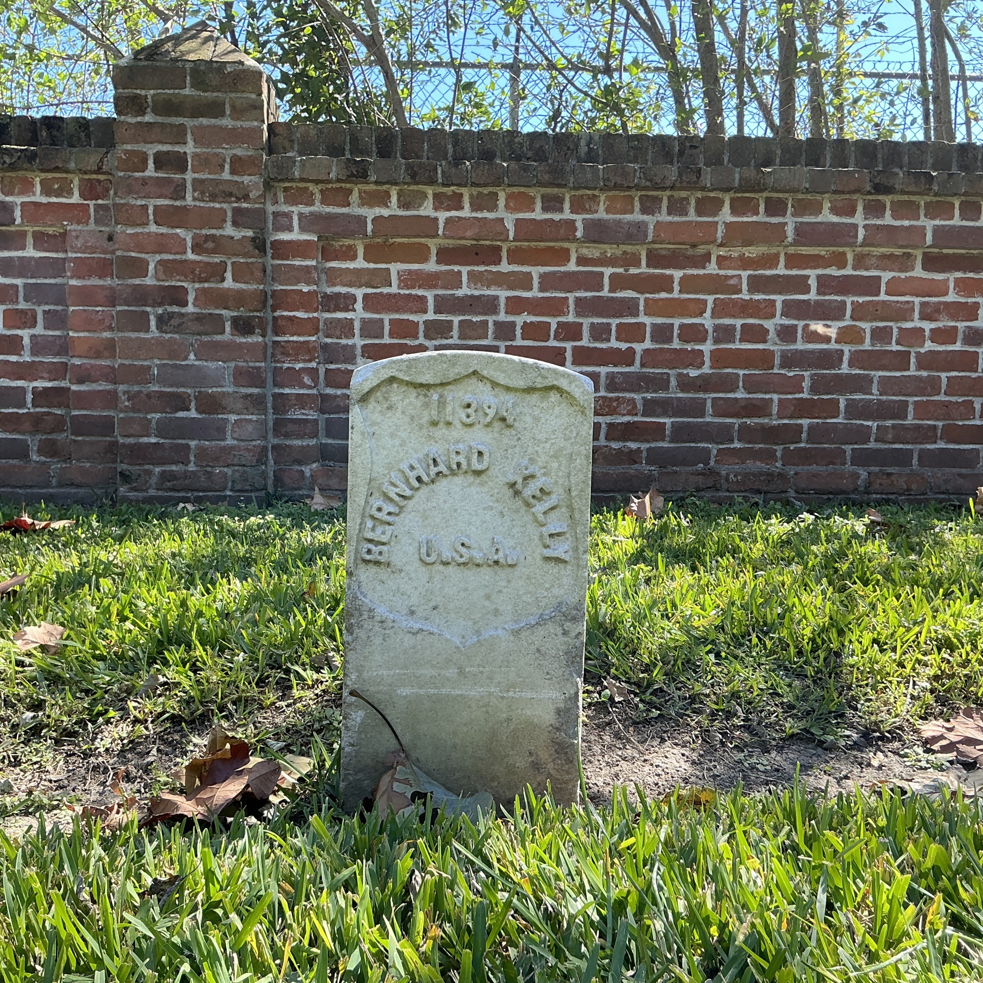 Front of historic upright marble headstone with recessed shield face.