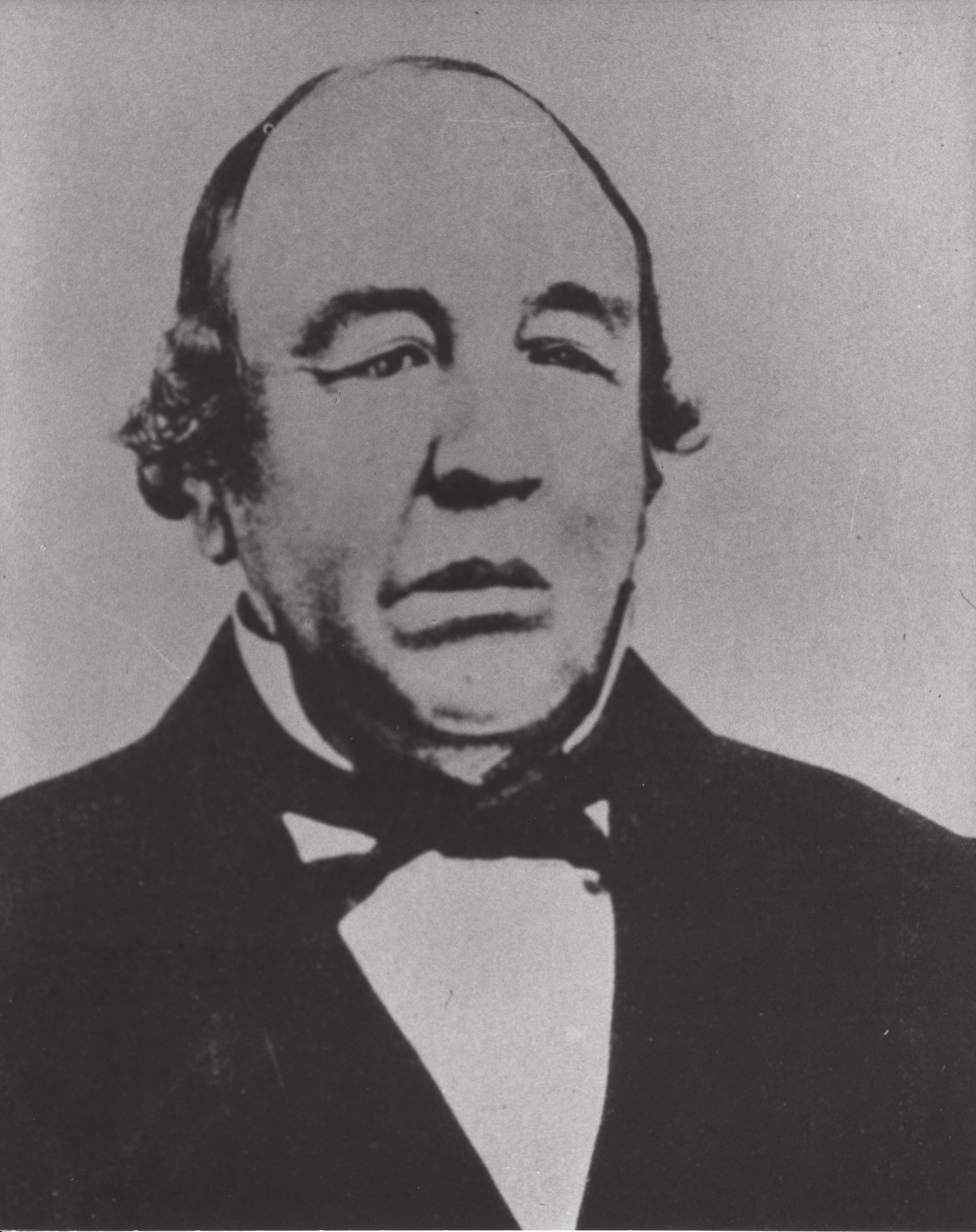 Black and white portrait of a man with long face in formal attire