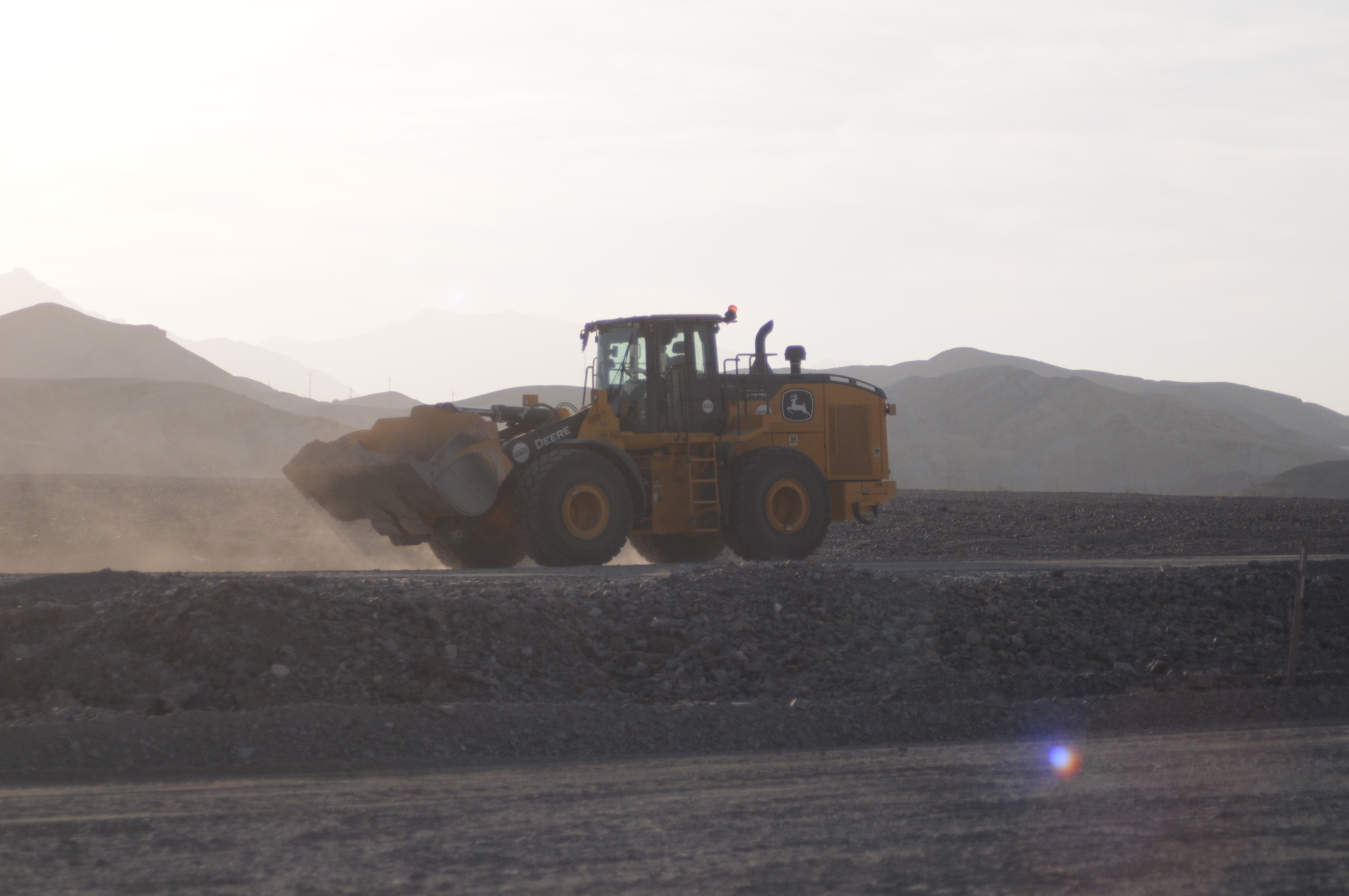 a large tractor moving gravel in a desert canyon