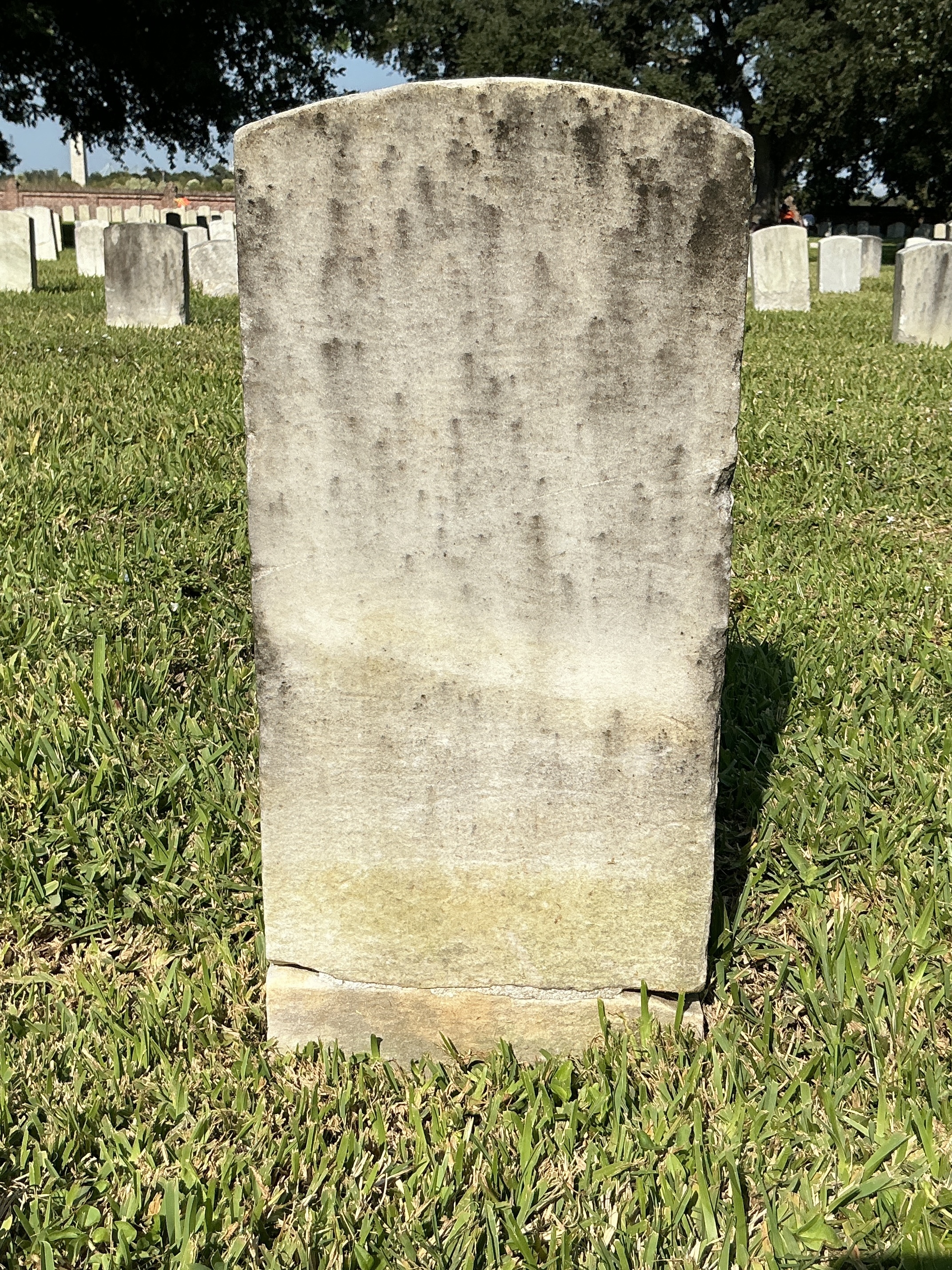 Back of historic upright marble headstone with recessed shield with recessed lettering face.