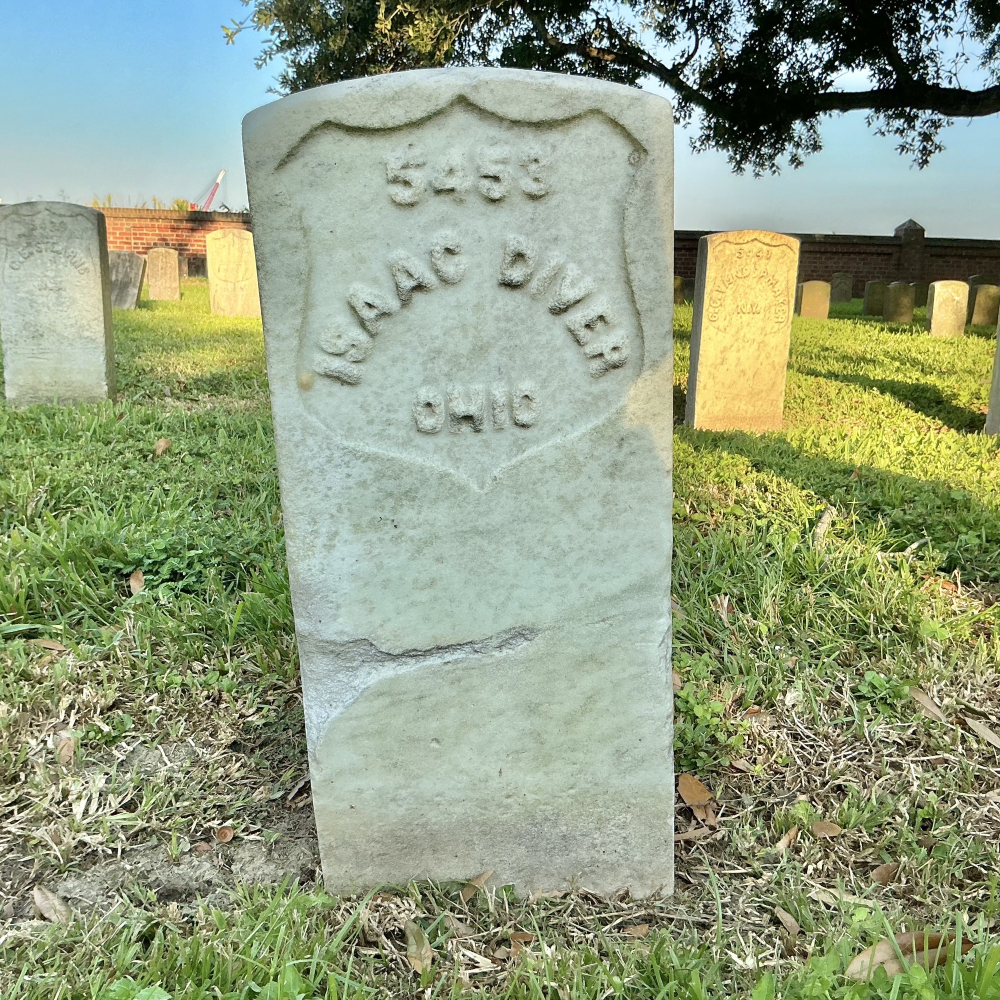 Front of historic upright marble headstone with recessed shield face.