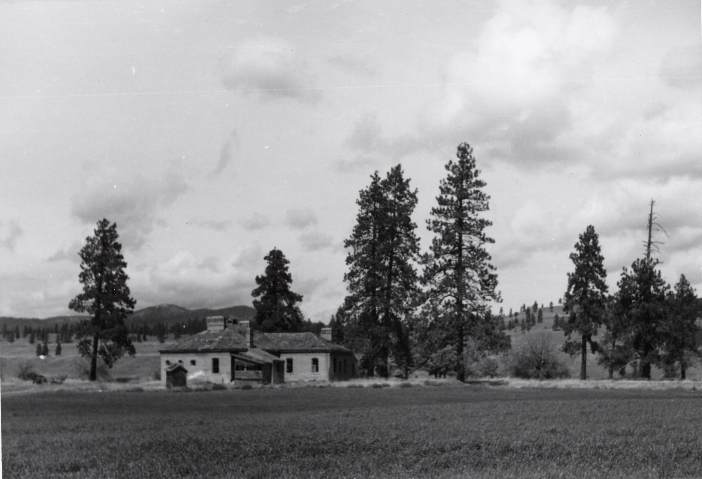 Black and white photograph of a building in a field