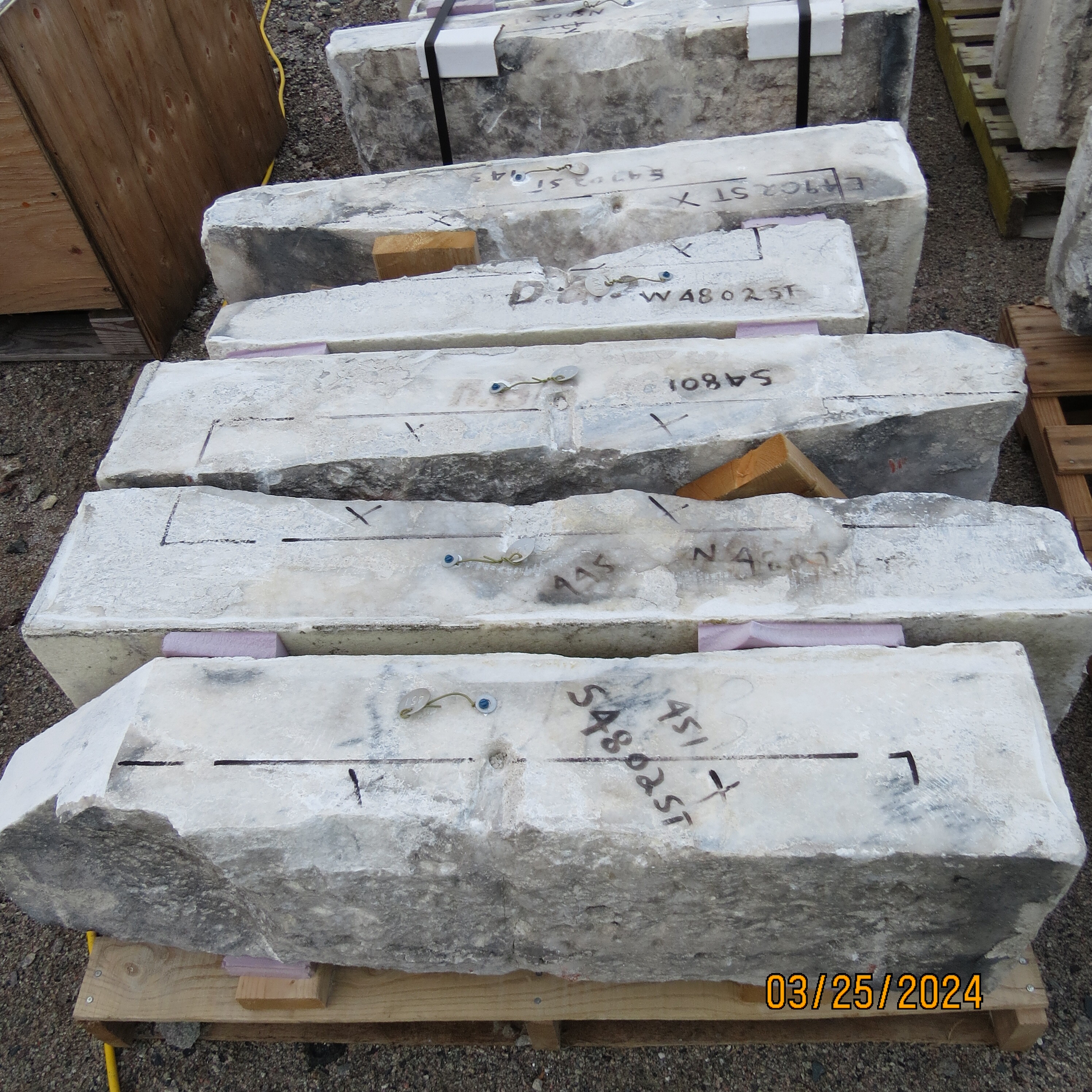 A column of 5 marble pieces of the Monument. Each one has numbers and lines marked on them. 