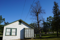 A modest white house with green trim