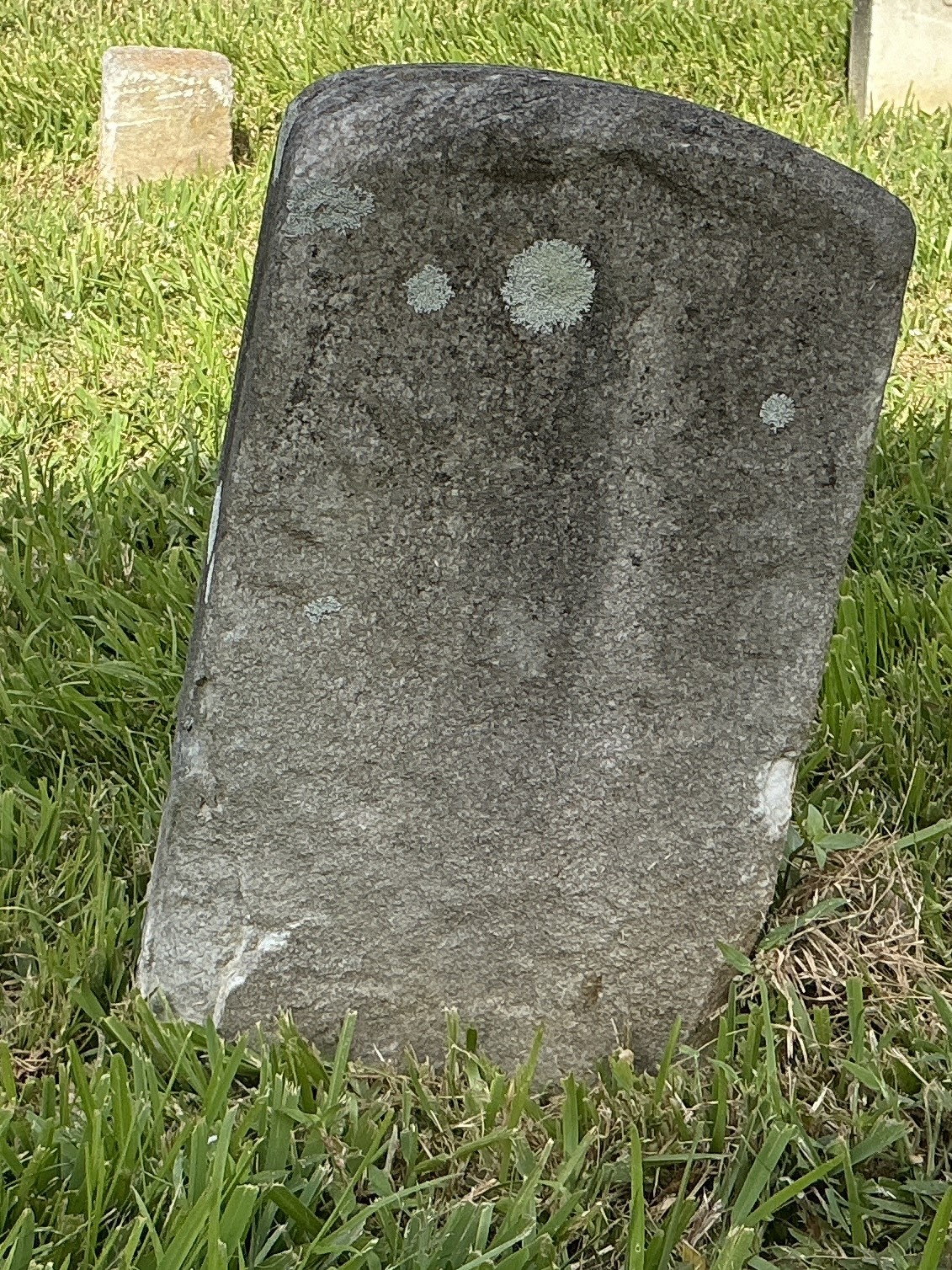 Front of historic upright marble headstone with recessed shield face.