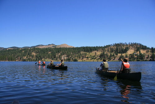 Color photograph of three canoes on a lake