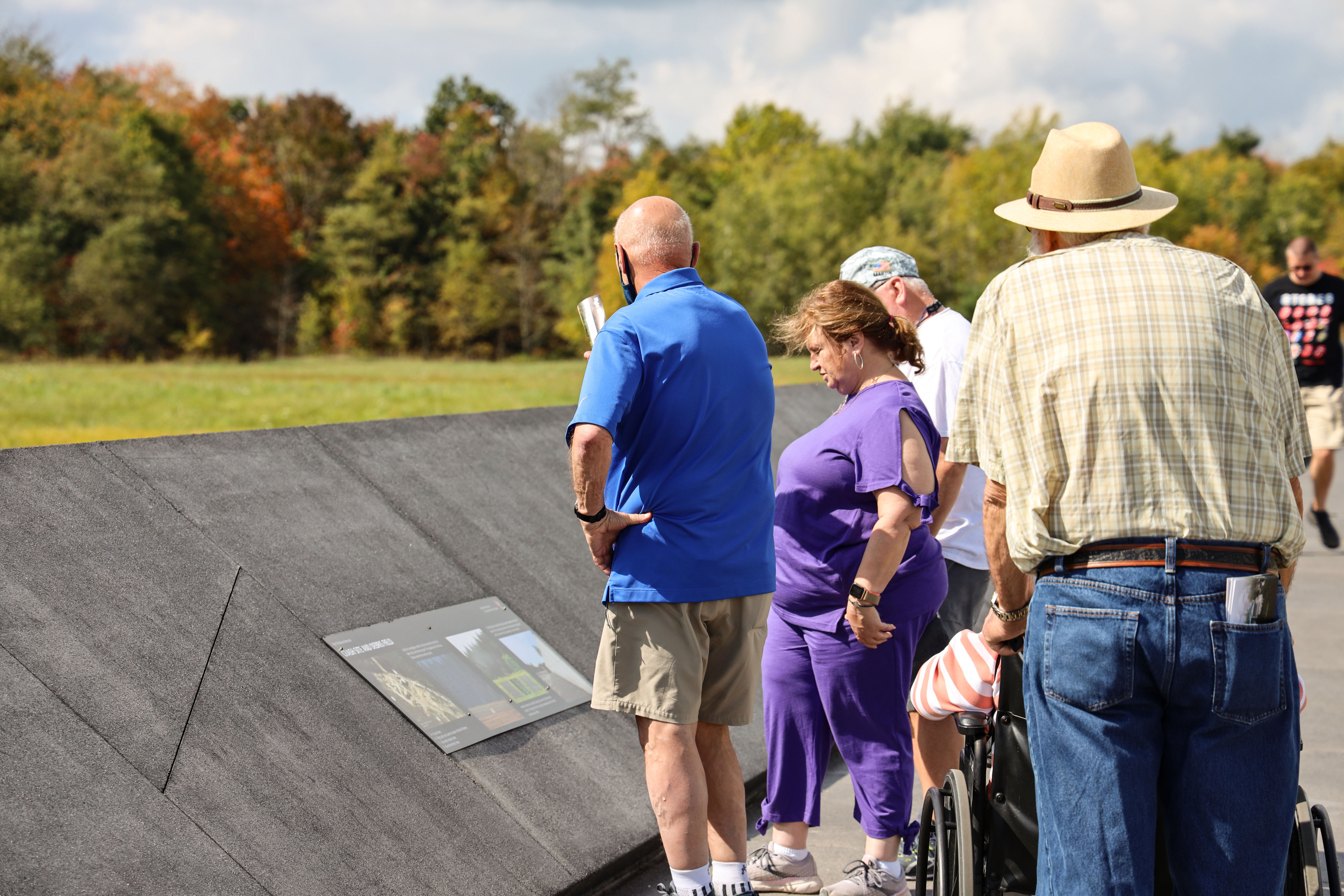 Visitors looking at informational panels at the Memorial Plaza Walkway.
