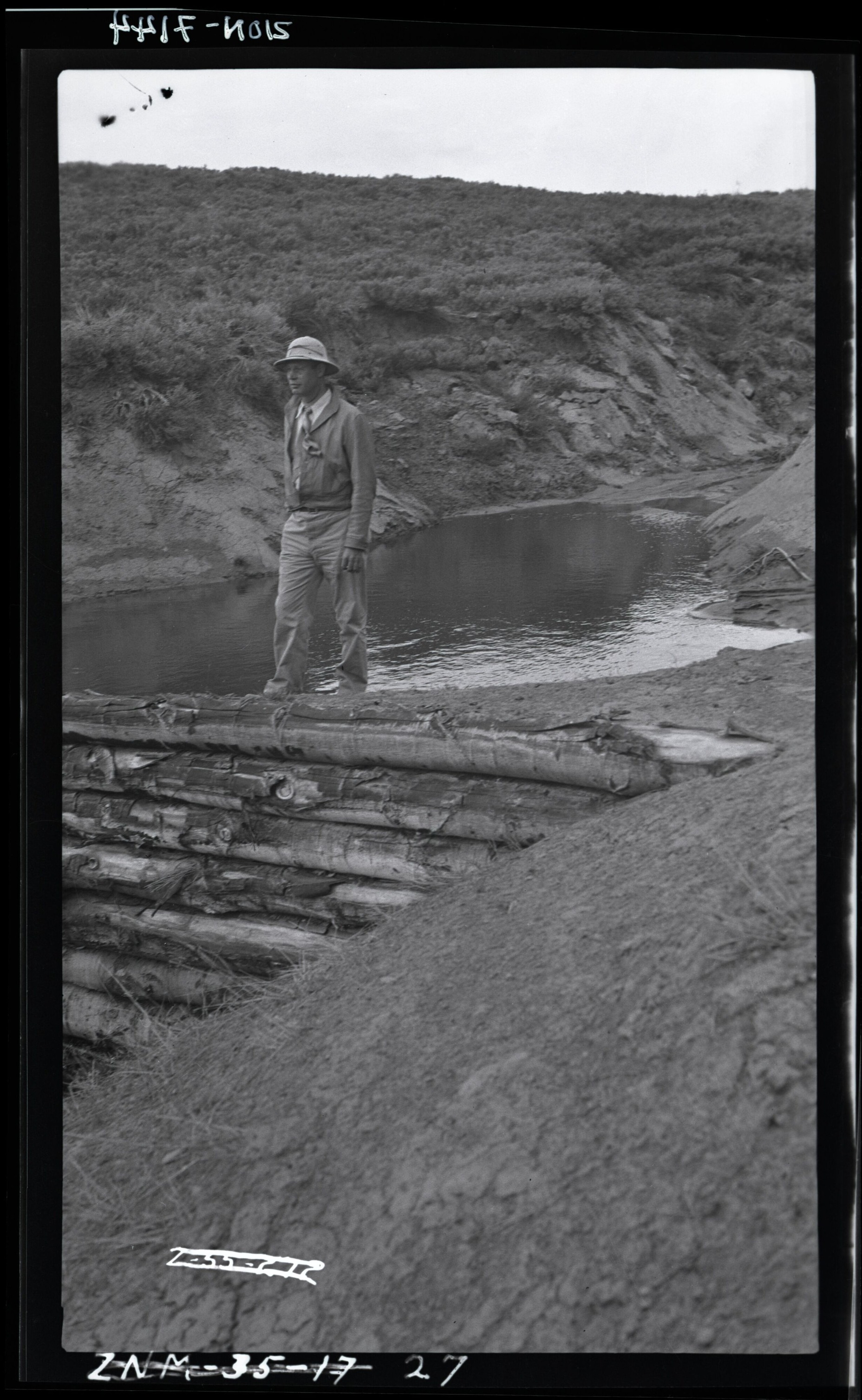 B&W negative of Blue Springs area with person on top of log dam.