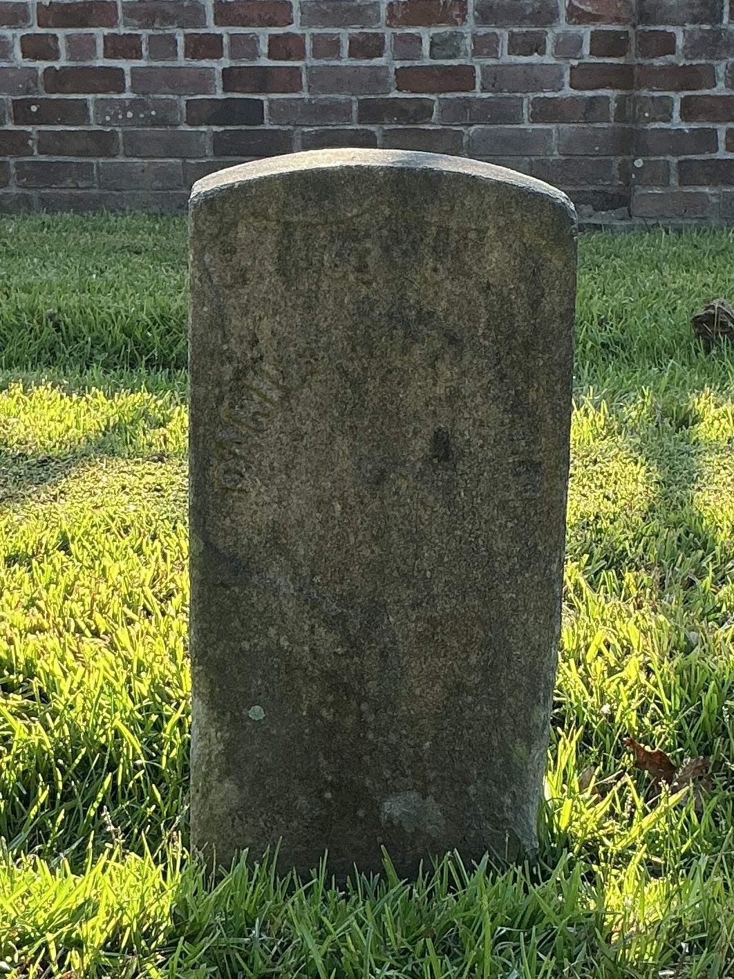 Front of historic upright marble headstone with recessed shield face.