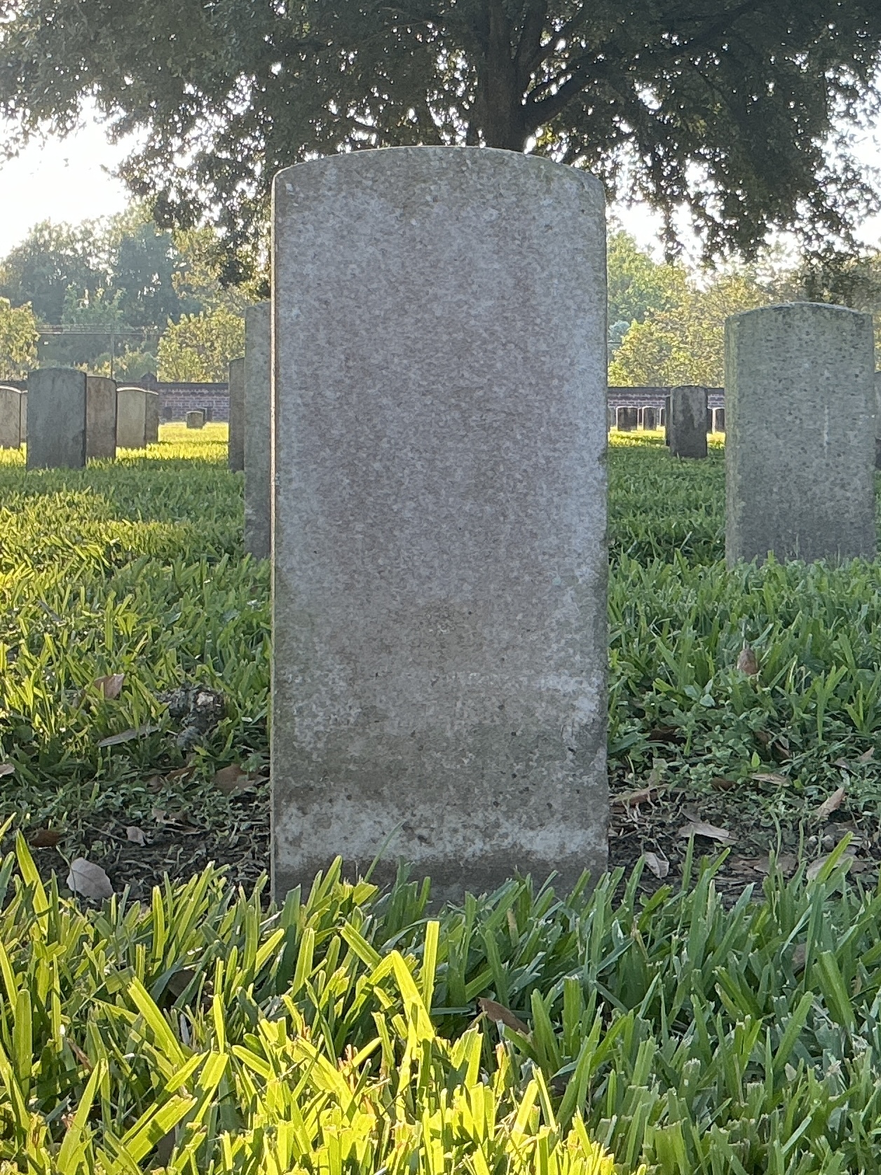 Back of historic upright marble headstone with recessed shield face.