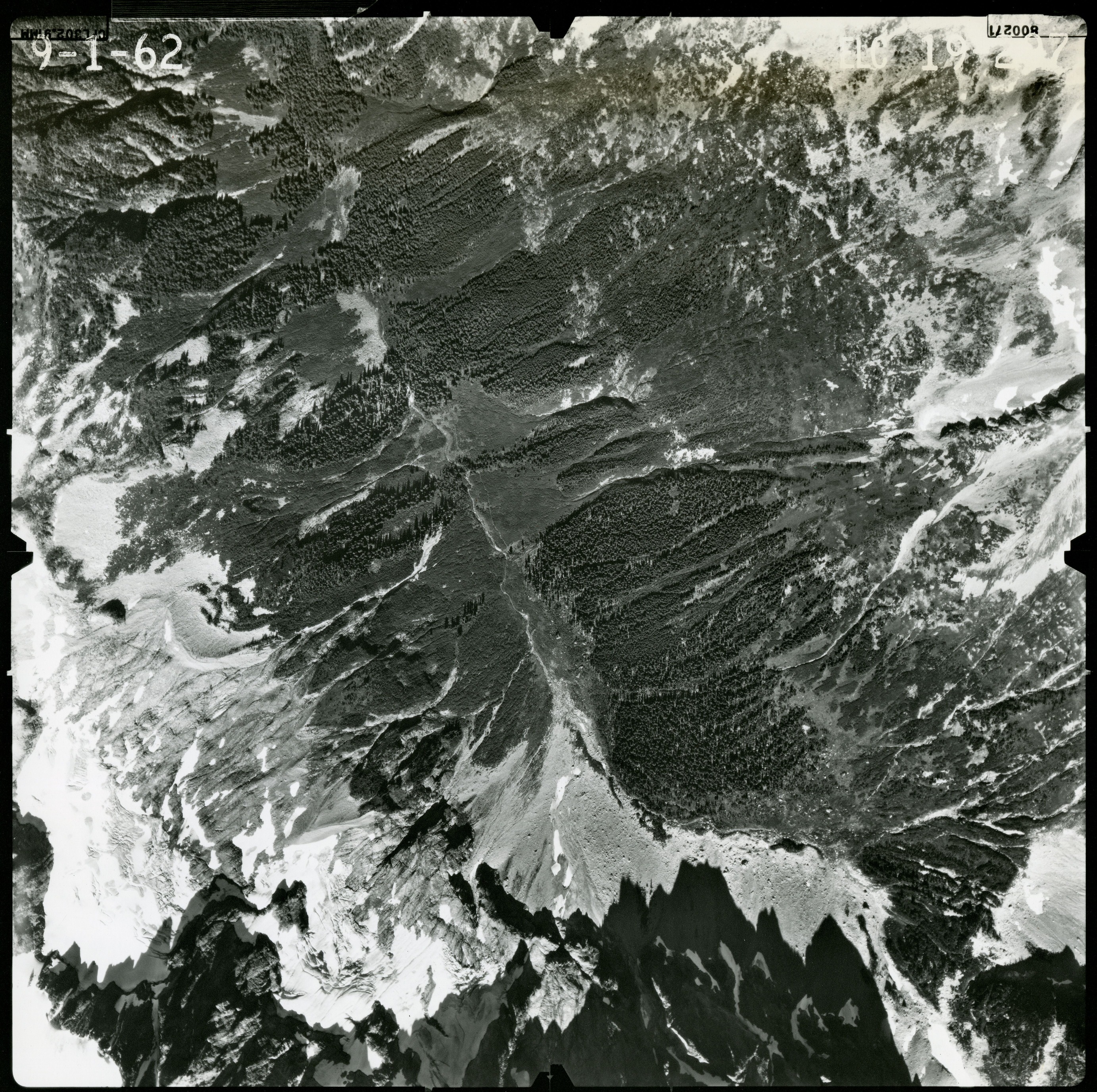Black and white aerial photograph of glaciated mountain peaks and valleys.