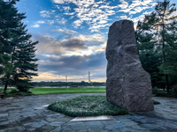 Granite monolith on a plaza with Washington Monument in the distance across a river