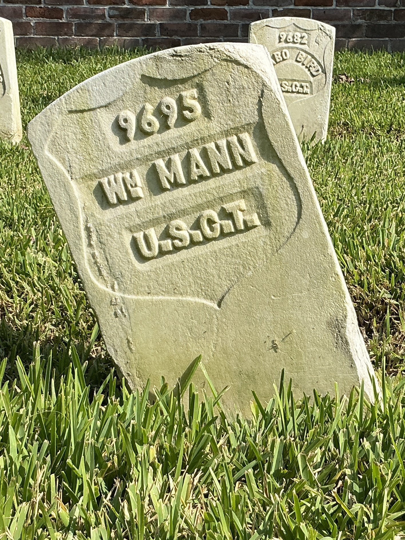 Front of historic upright marble headstone with recessed shield with recessed lettering face.