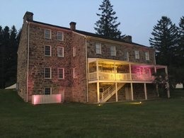 The Lemon House illuminated in purple and yellow light for the centennial of the 19th Amendment. 