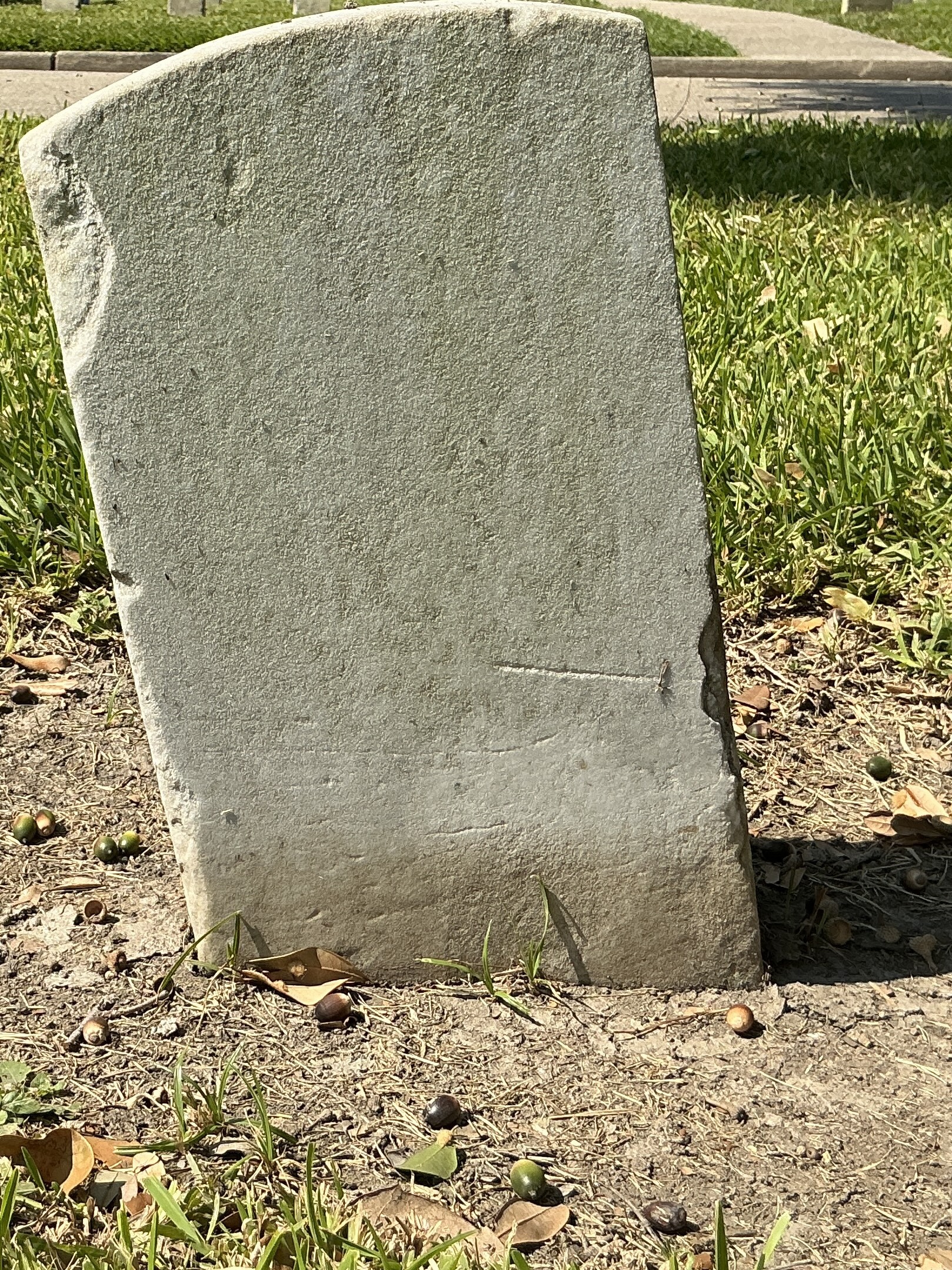 Back of historic upright marble headstone with recessed shield face.