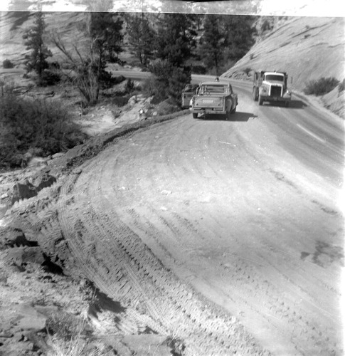 Construction trucks driving on road during east side road repair and turn out construction.